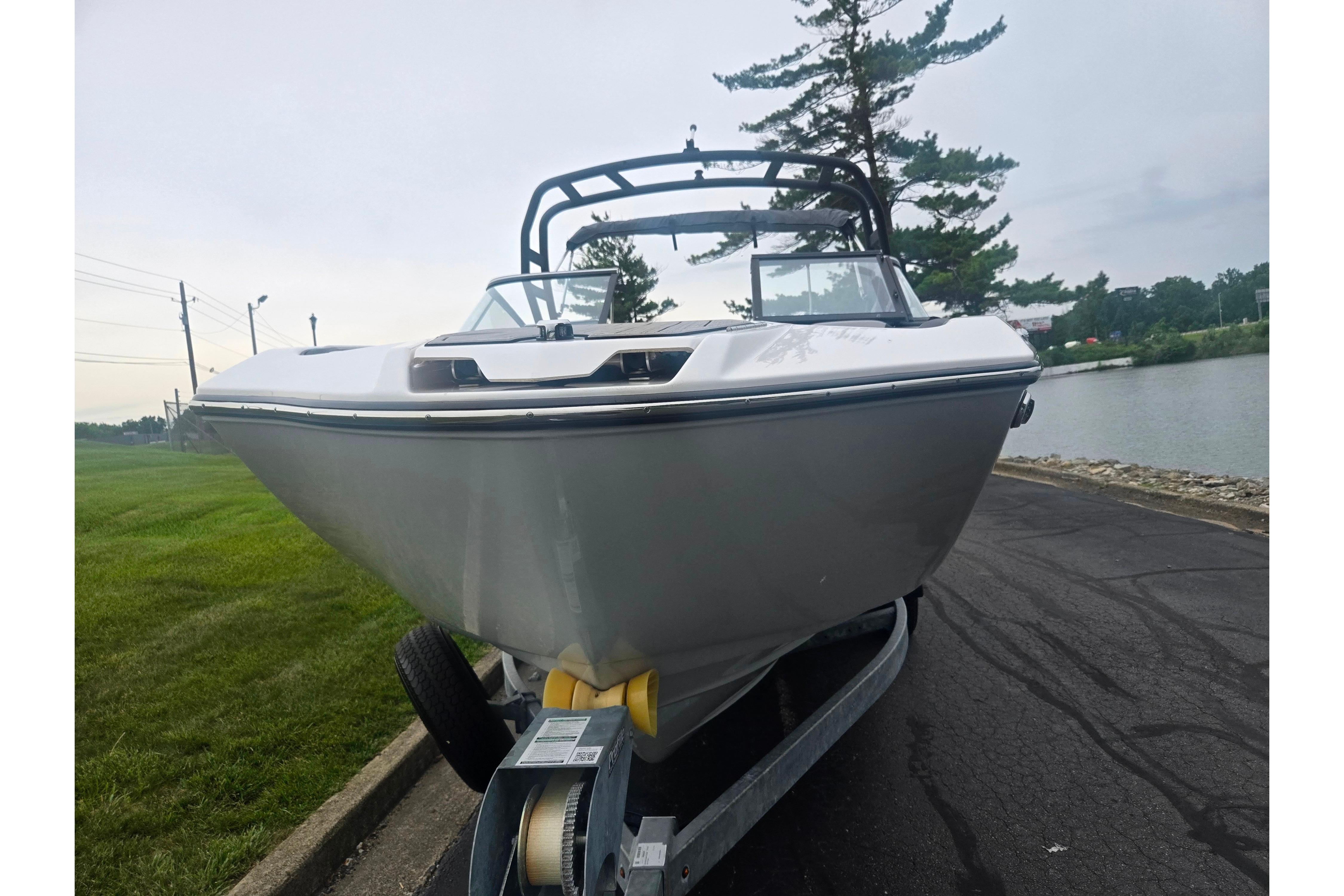 2023 Yamaha Boats 252S on trailer by lakeside, front view.