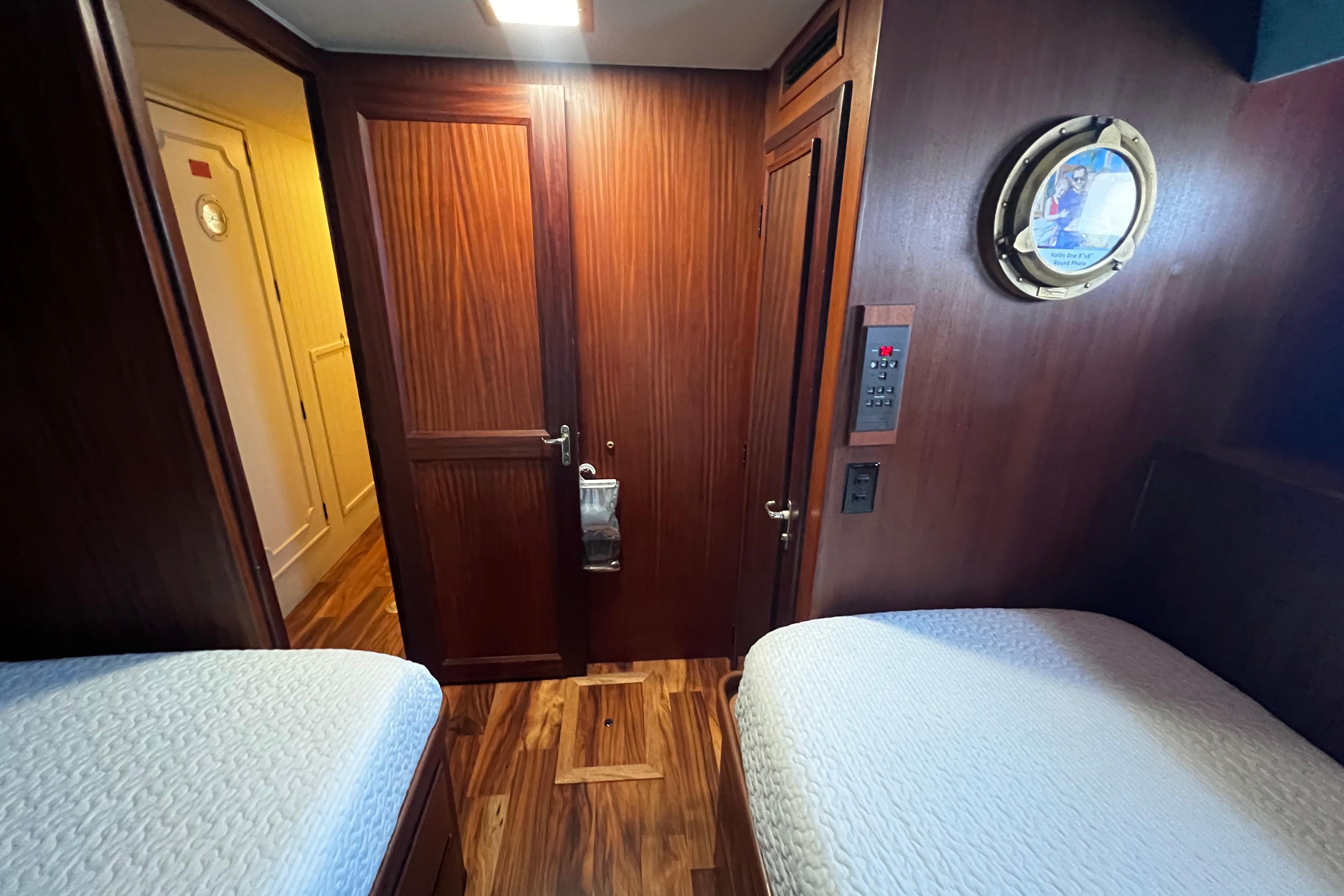 Interior of 1987 Hatteras 70 Cockpit Motor Yacht with wood paneling and twin beds.