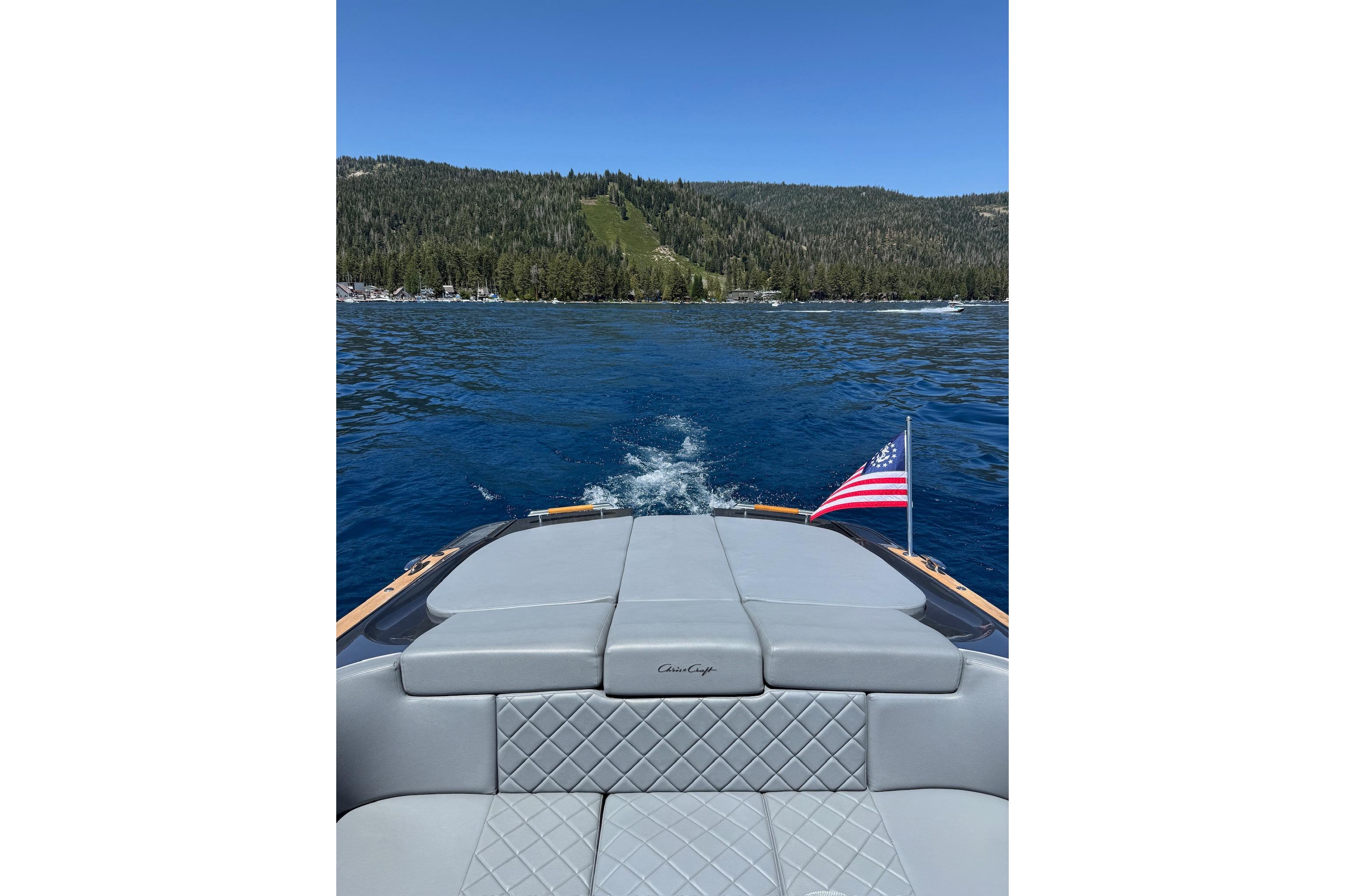 2021 Chris-Craft Corsair 34 cruising on a scenic lake with forested hills.