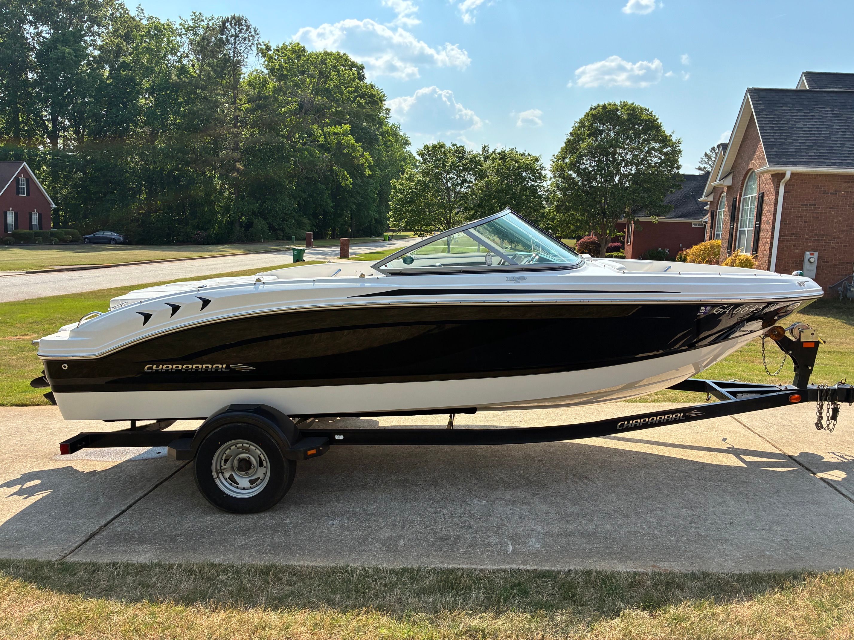 2012 Chaparral 19 H2O Sport on a trailer in a residential area.