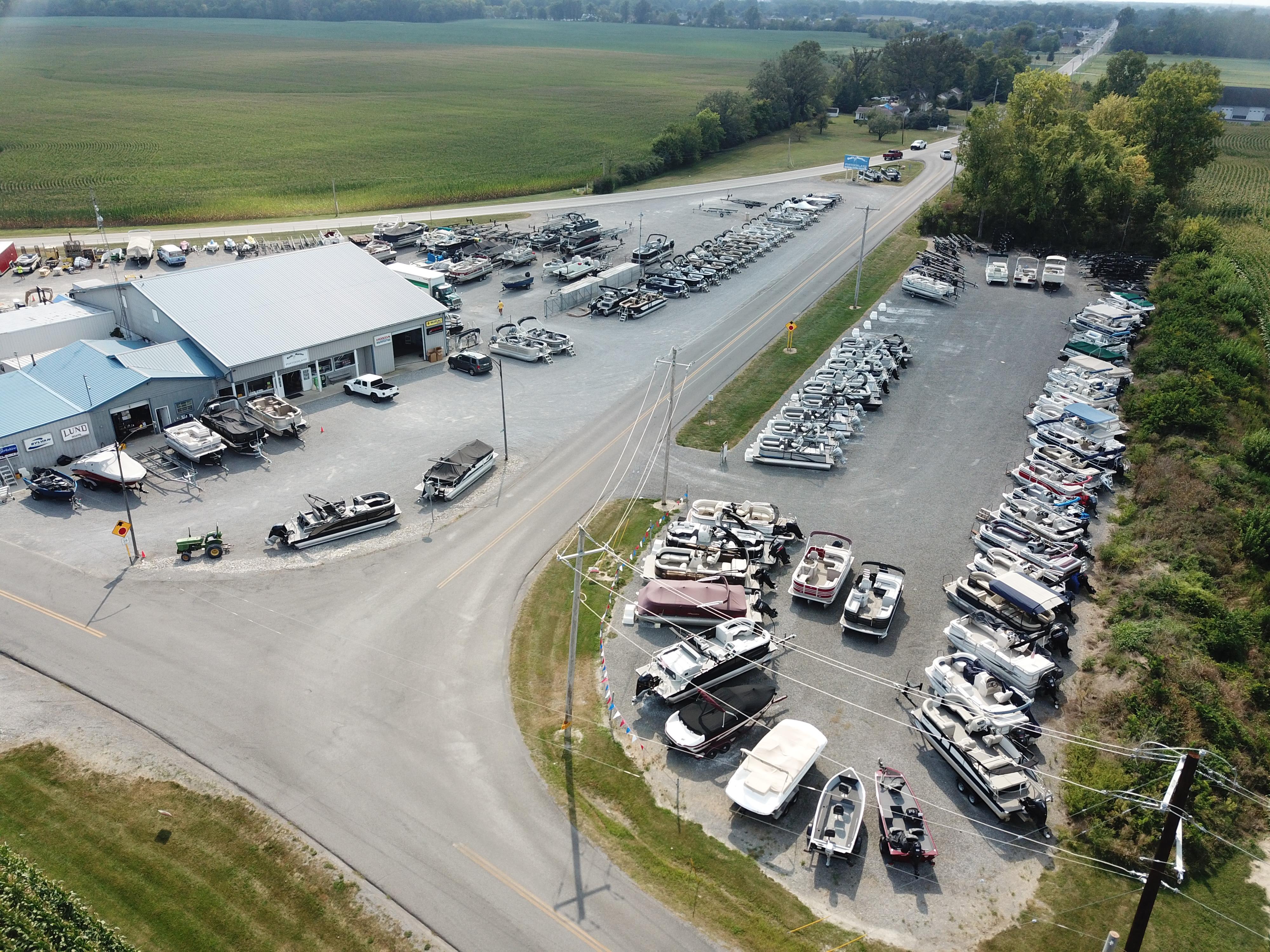Aerial view of a boat dealership with various boats, including Lowe SS230, in a rural setting.