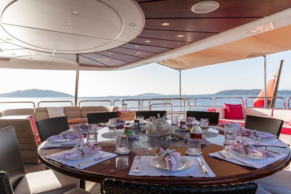 Luxurious dining setup on 2008 Benetti Classic 120 yacht, overlooking serene ocean views.