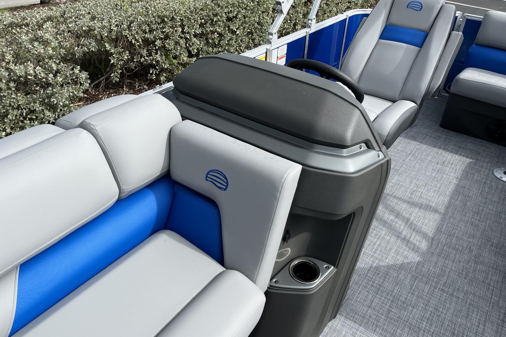 2026 Sun Tracker Party Barge 20 DLX interior with gray and blue seating, steering console.