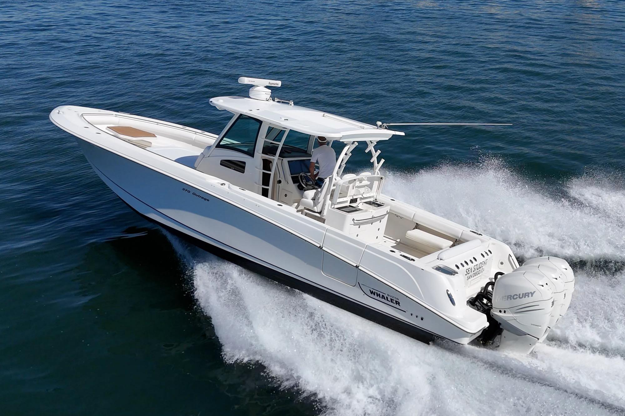 2015 Boston Whaler 370 Outrage cruising on open water, showcasing sleek design and powerful engines.