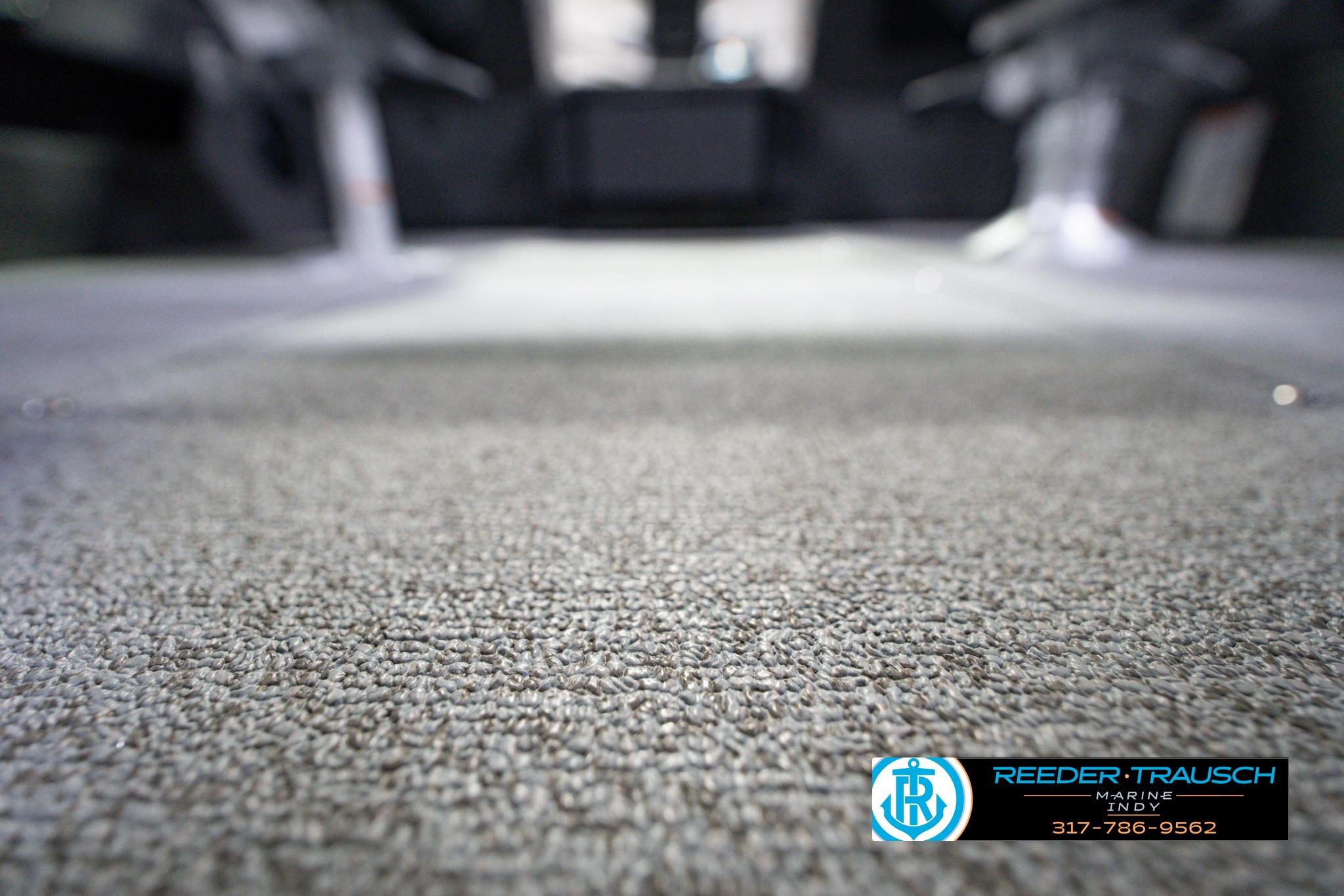 Carpeted interior of 2026 Lund 1875 Impact XS SS boat, Reeder-Trausch Marine logo visible.