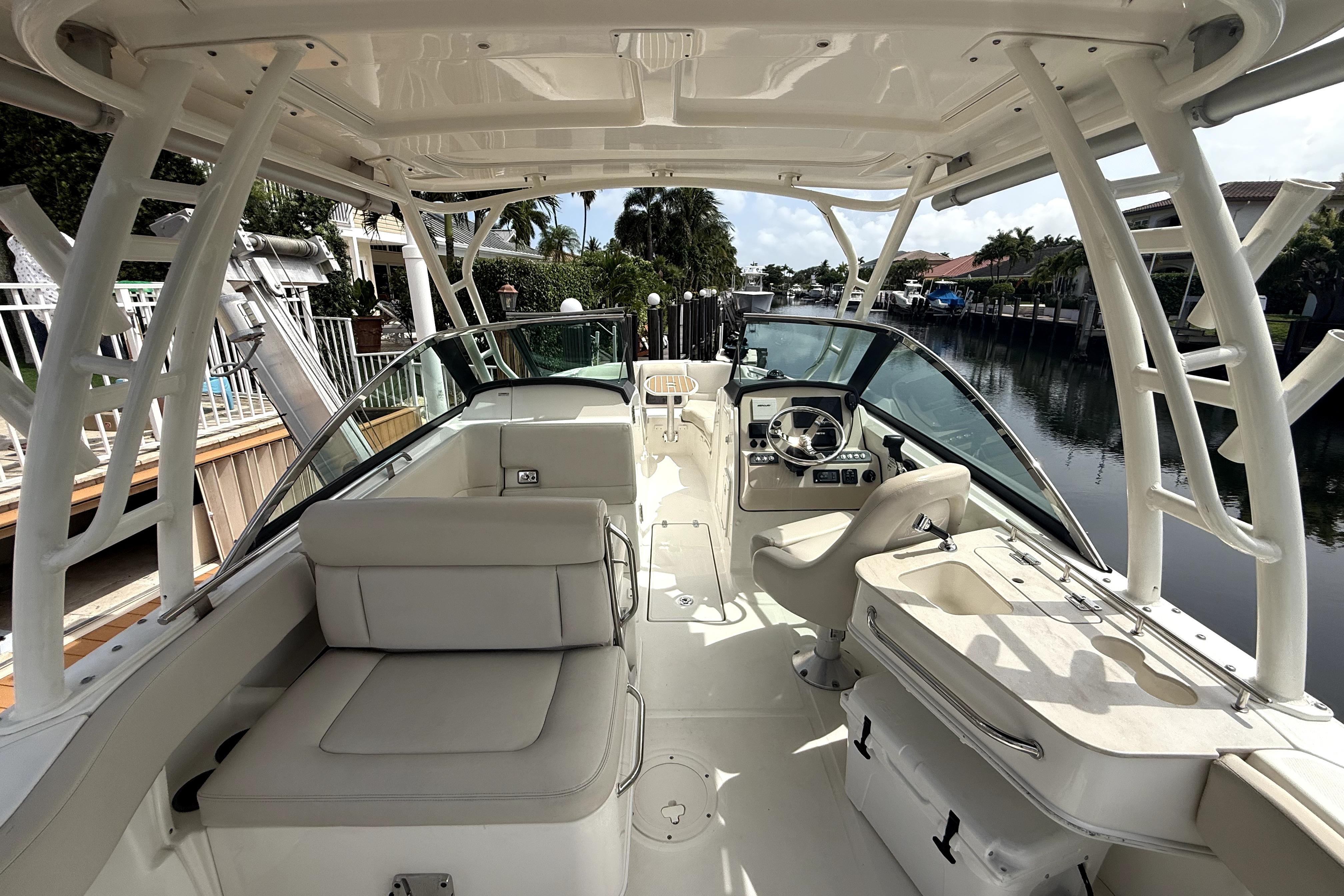 2018 Boston Whaler 230 Vantage boat interior with seating and helm, docked by a canal.