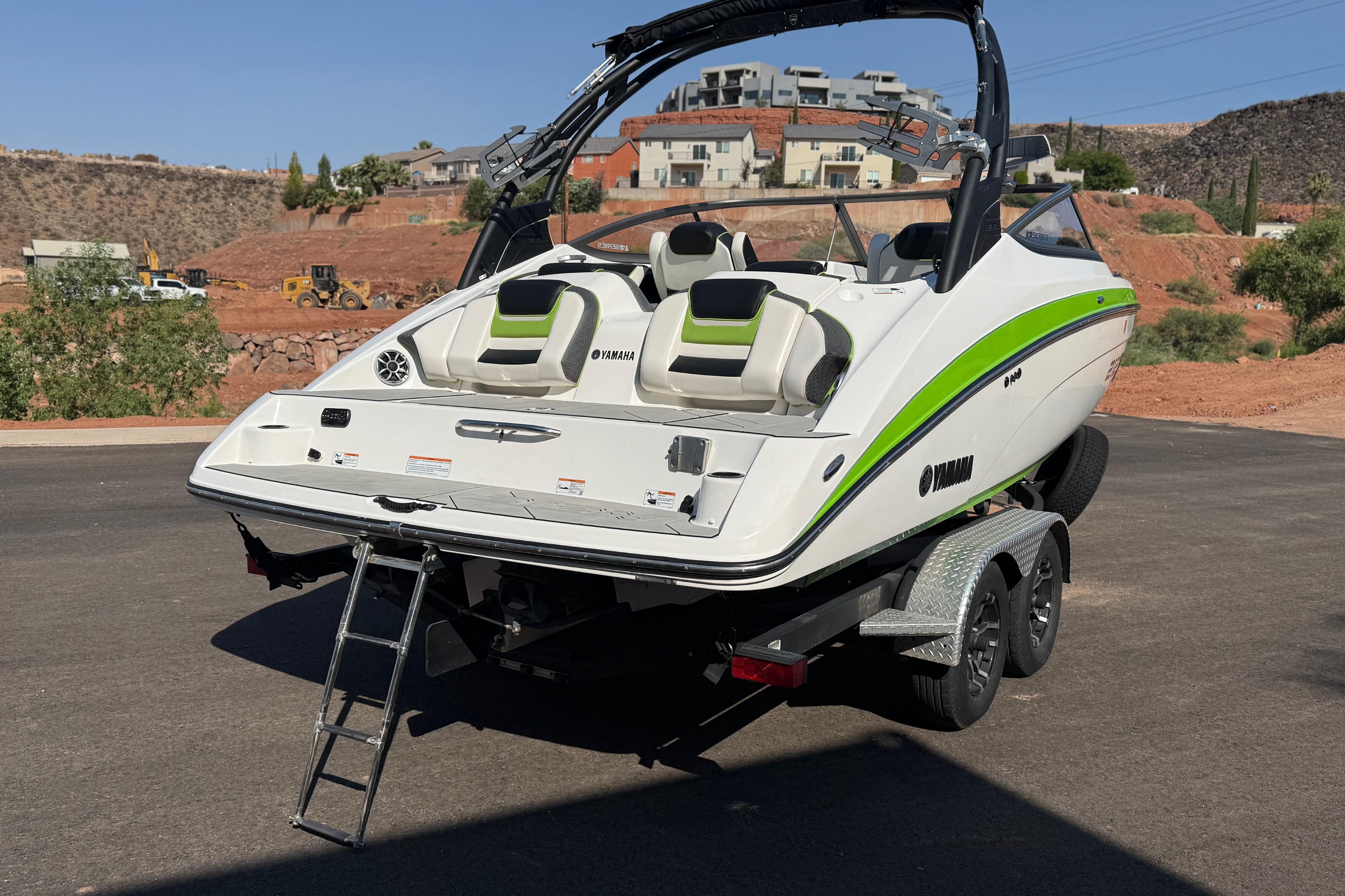 2022 Yamaha Boats 212XE on trailer, featuring sleek design and vibrant green accents.