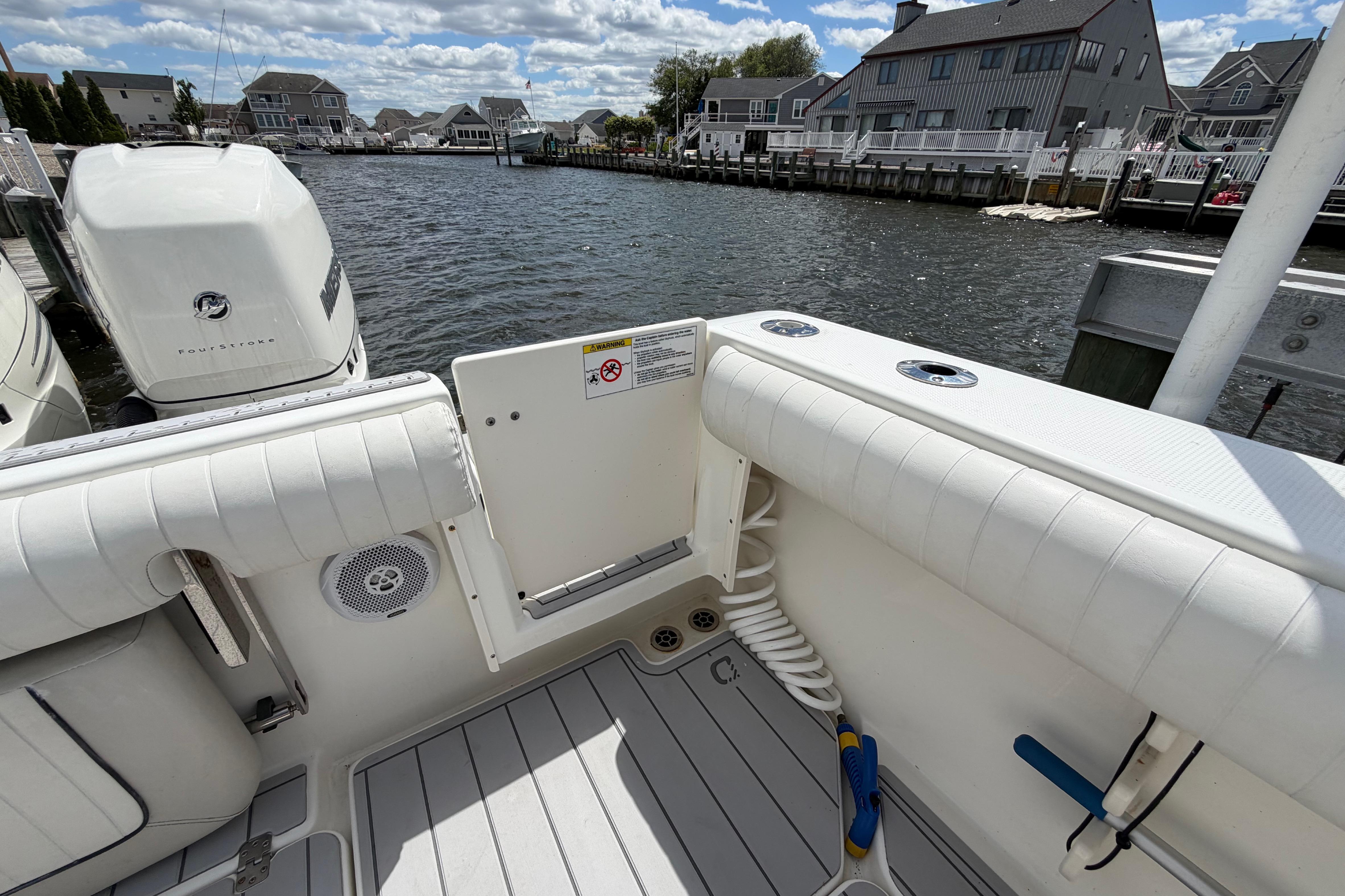 2017 Mako 284 Center Console boat docked, featuring spacious deck and powerful outboard engines.