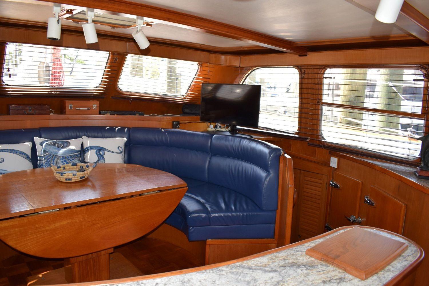 Interior of 1980 Cheoy Lee 52 Motorsailer with blue seating and wooden table.