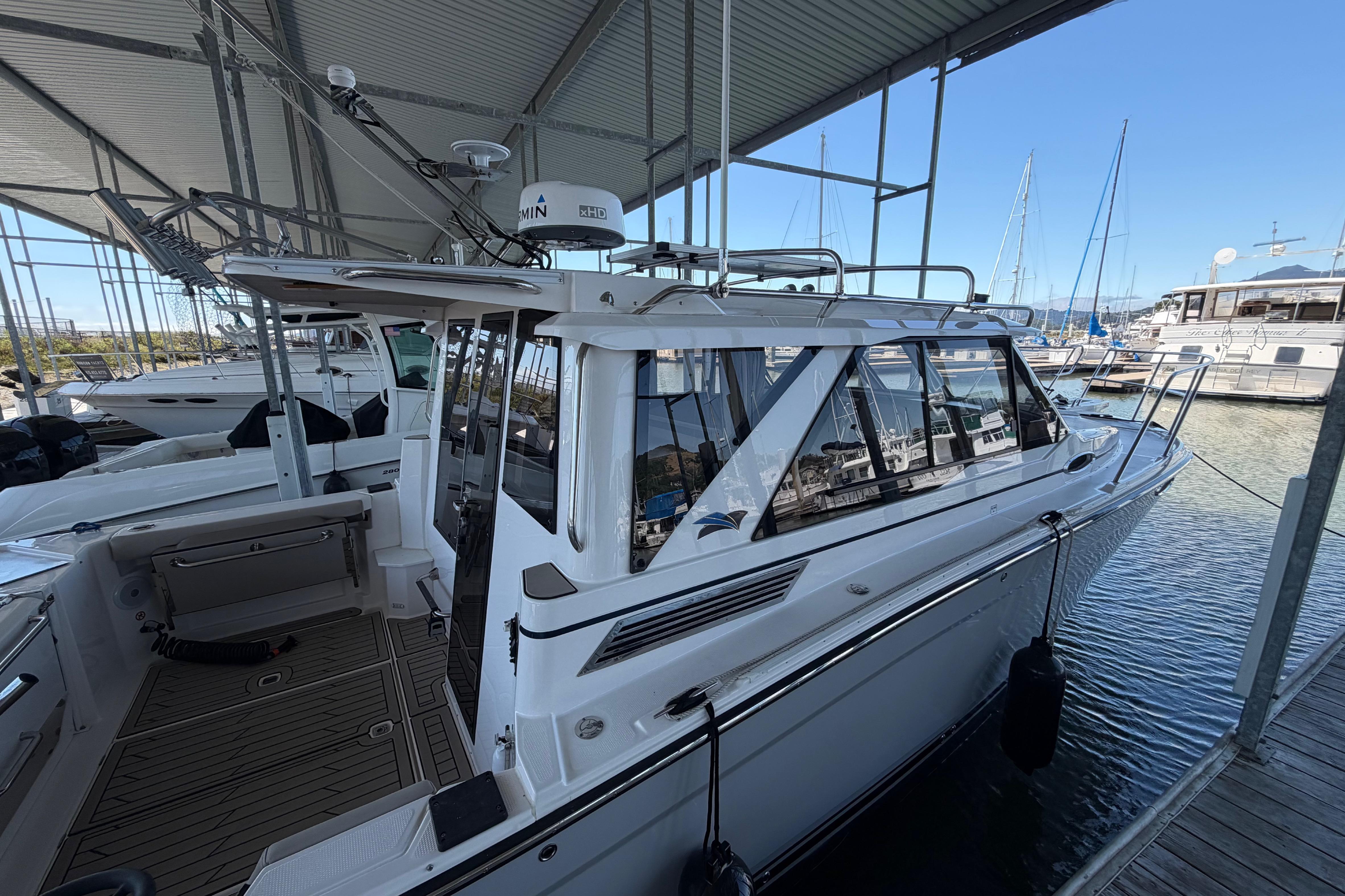 2023 Cutwater C-288 Coupe docked in a marina under a covered structure.