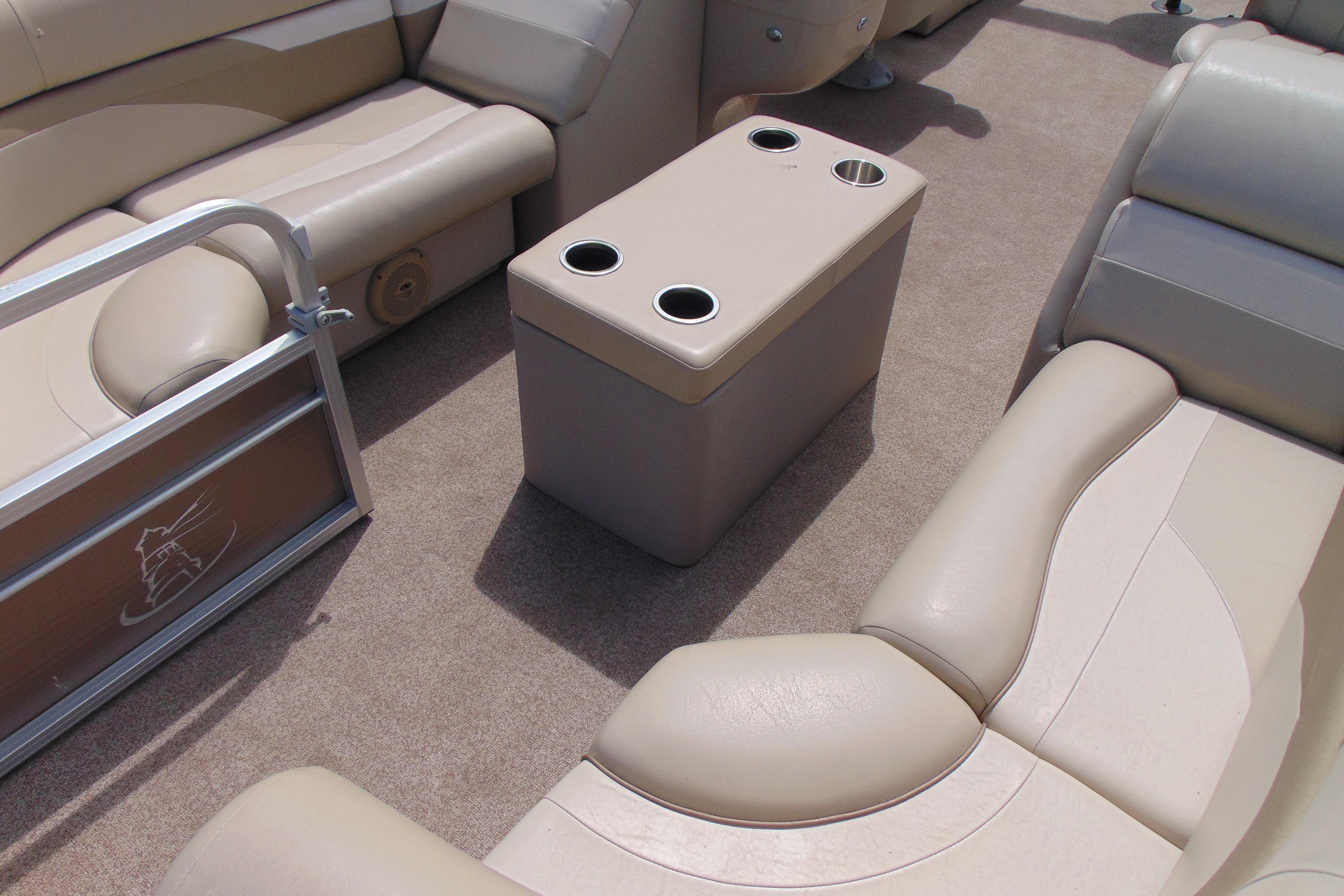 Interior of 2016 Misty Harbor 245 Adventure CU pontoon boat with beige seating and cup holders.