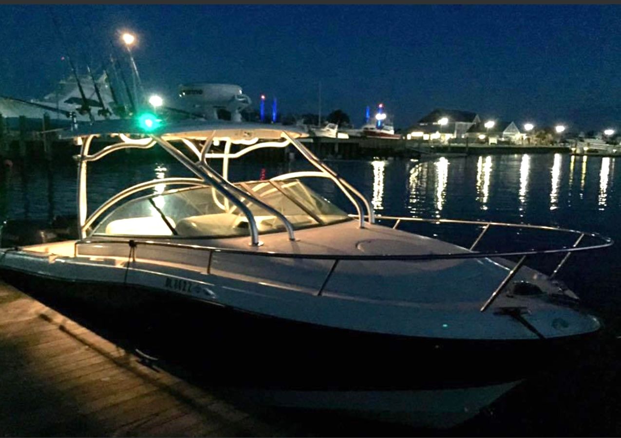 2023 Hydra-Sports Vector-VX at night, docked with lights reflecting on the water.