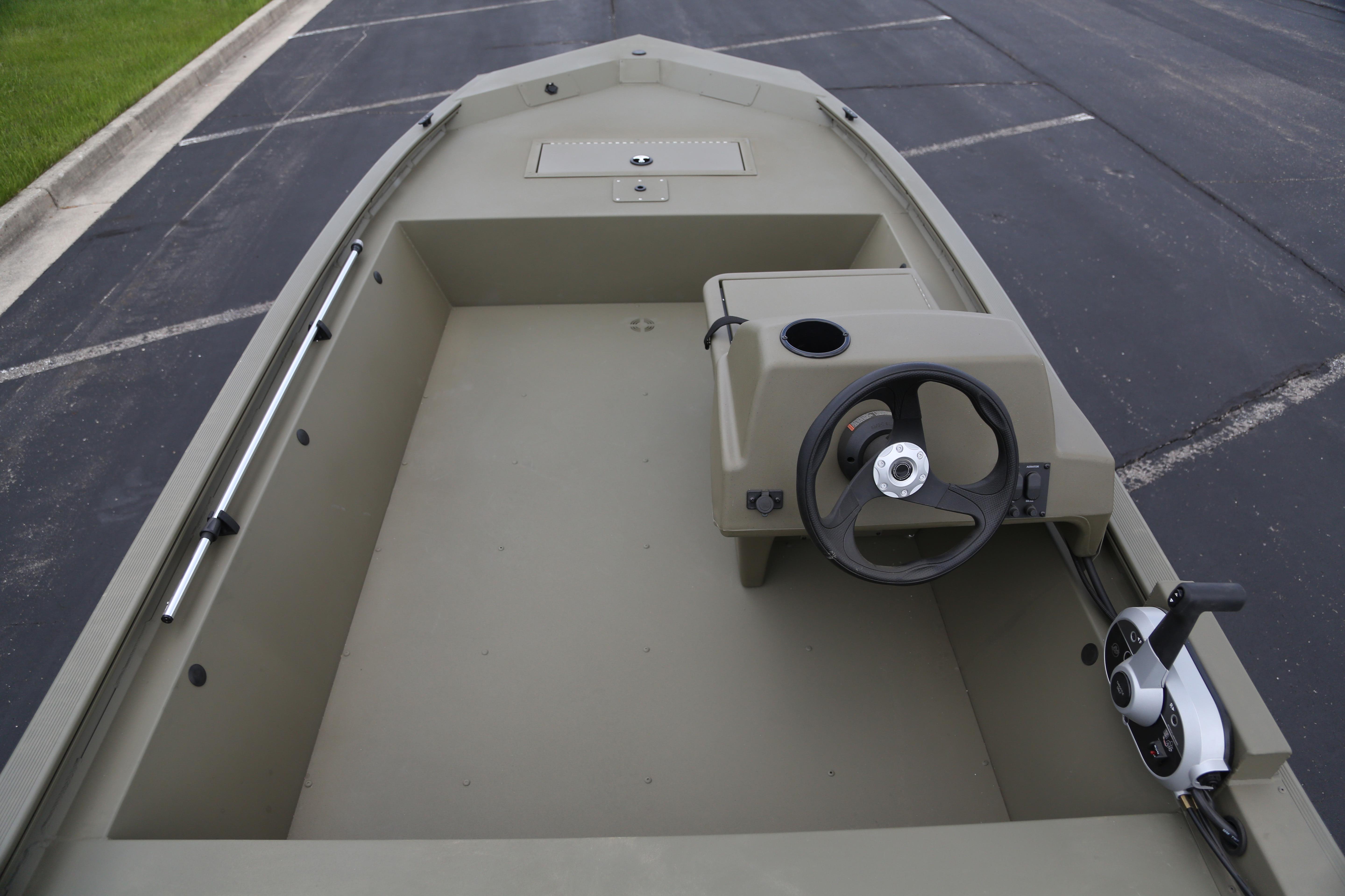 2026 Tracker Grizzly 1648 SC boat interior with steering console, parked on asphalt.