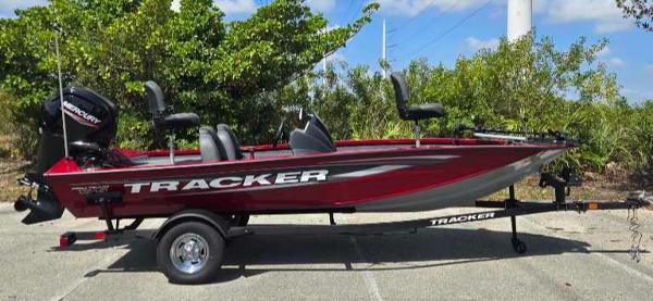 2025 Tracker Pro Team 175 boat on trailer, red color, parked outdoors.
