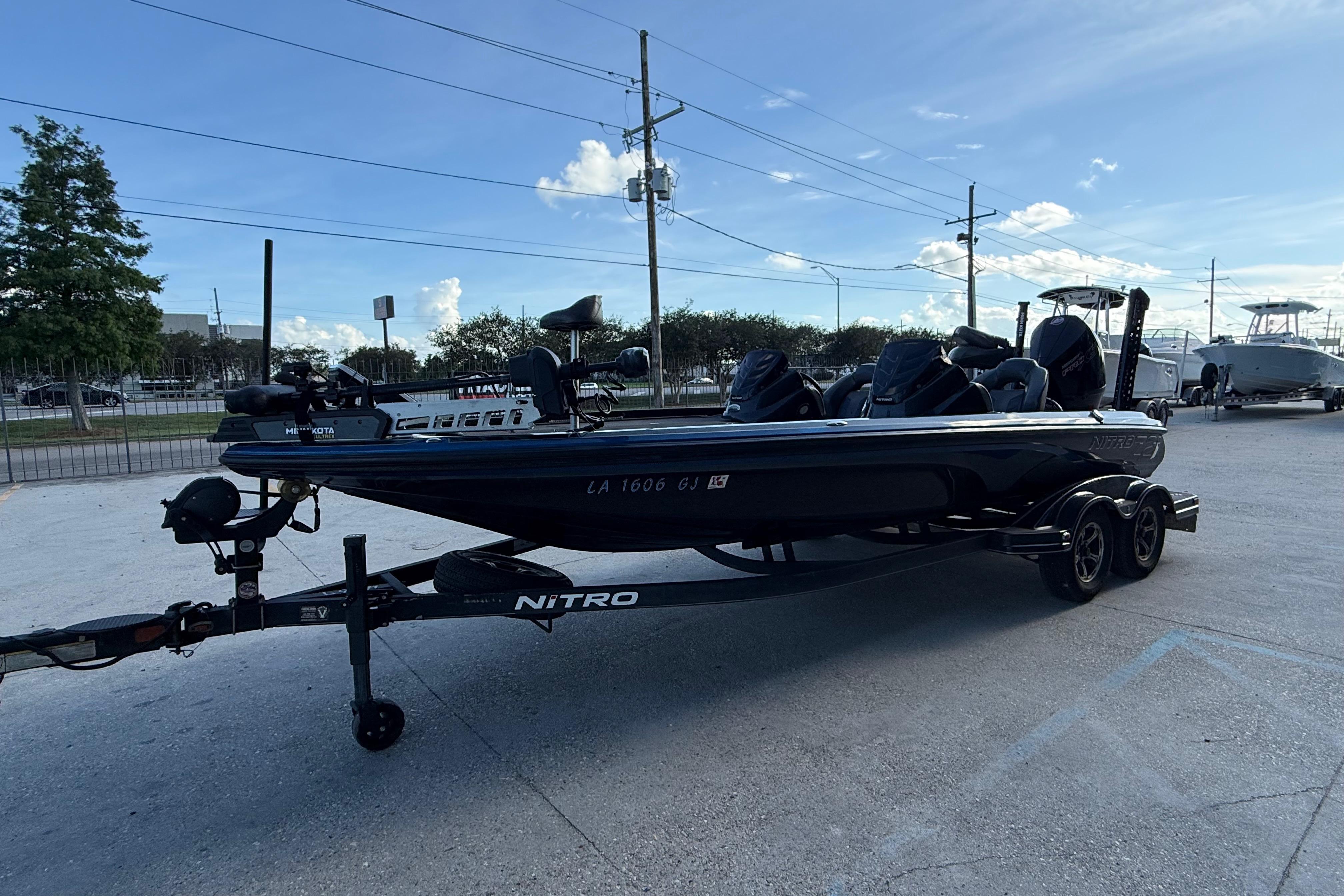 2018 Nitro Z21 boat on trailer in parking lot under clear blue sky.