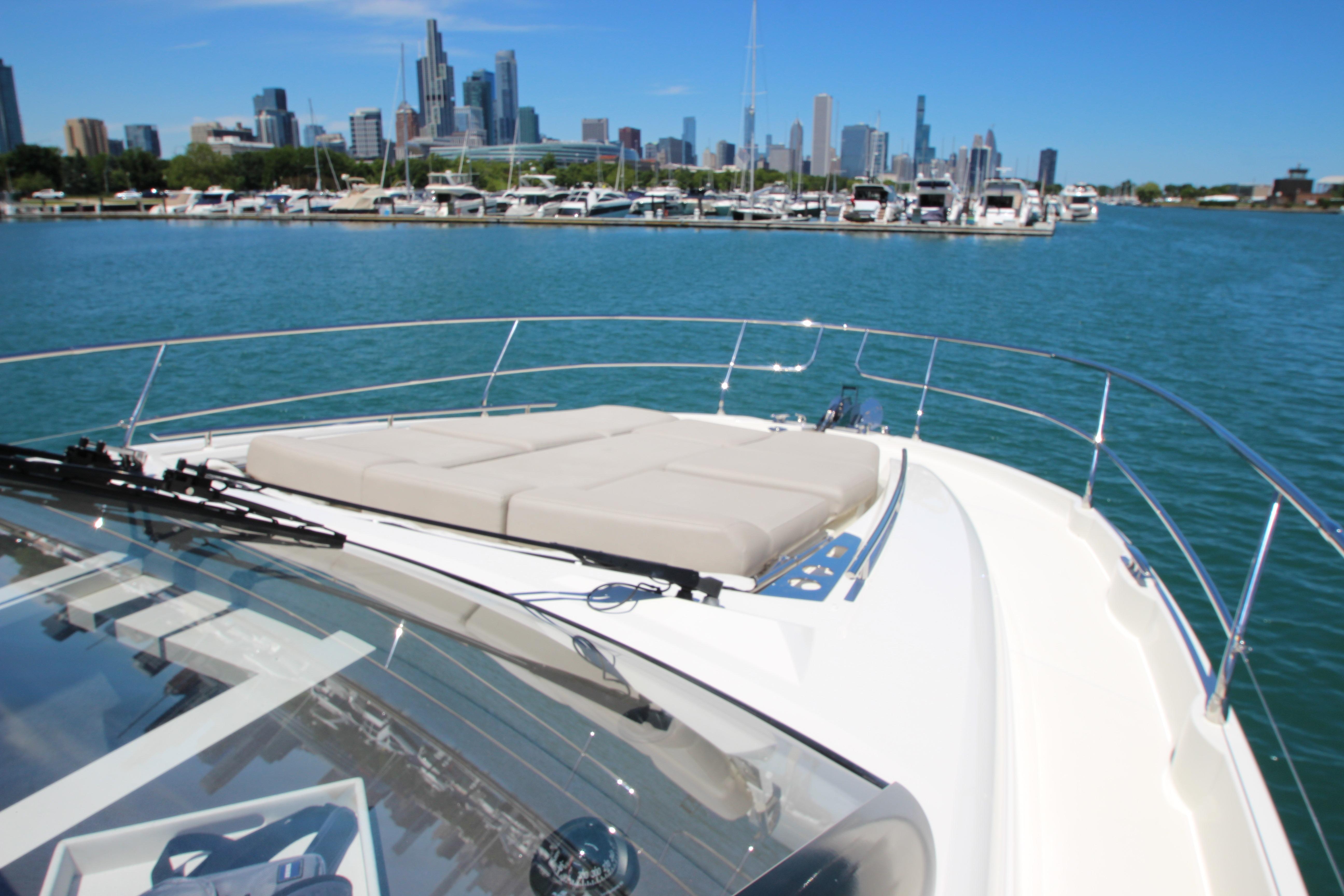Luxury 2022 Prestige 520 yacht with city skyline and marina backdrop.