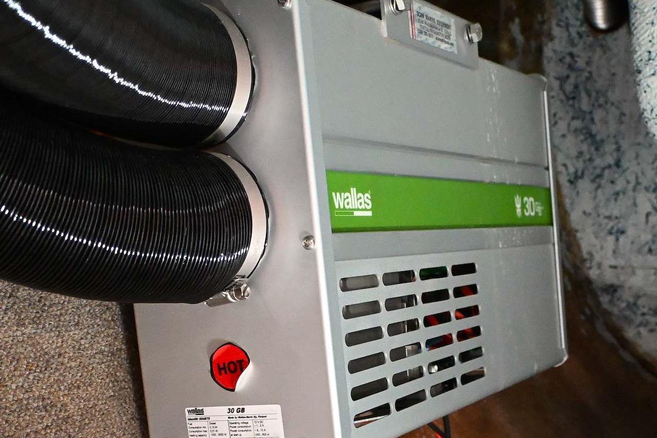 Wallas heater unit in a 1977 Mercator Offshore boat, featuring dual exhaust hoses.