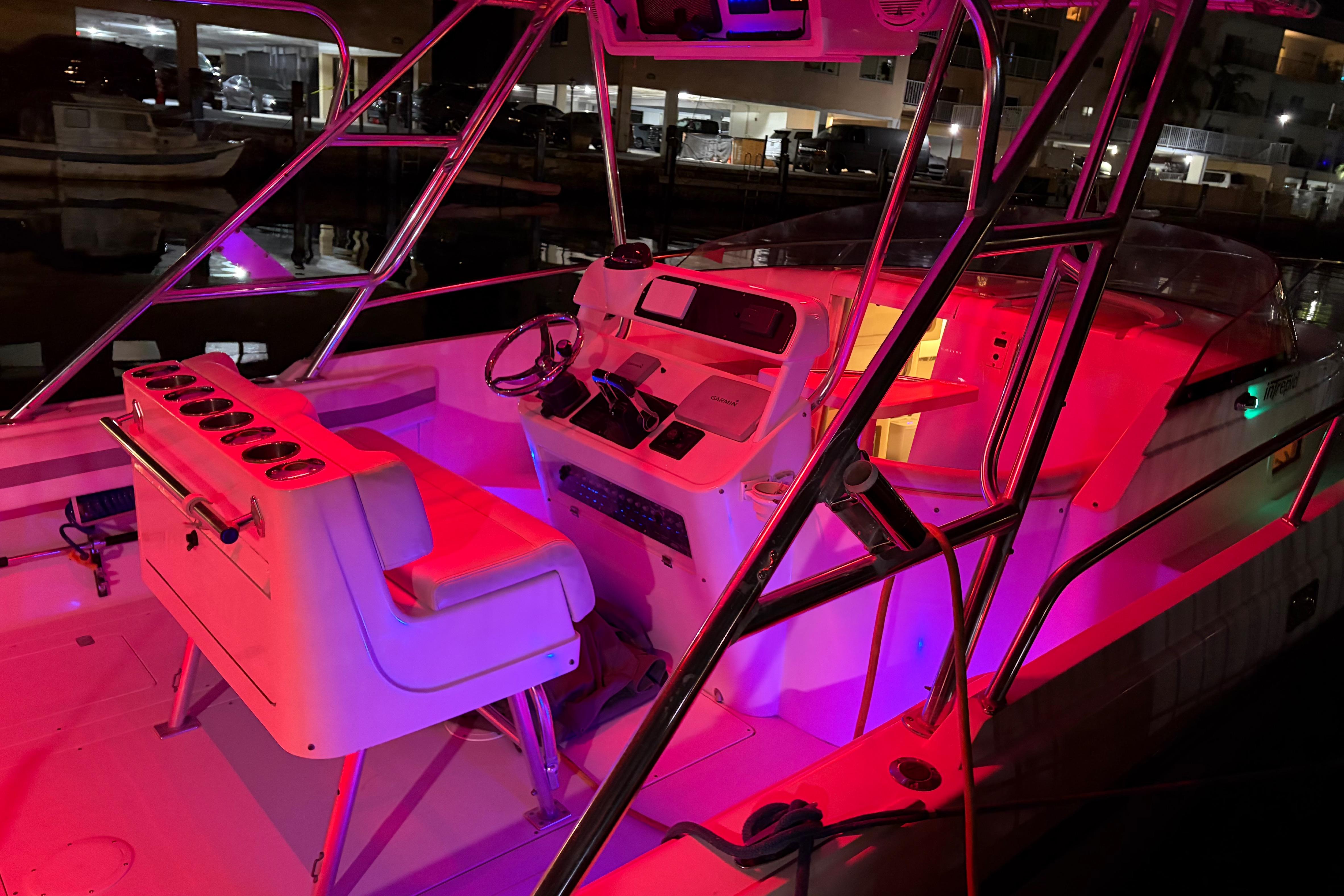 1998 Intrepid 339 Walkaround boat interior with vibrant red and purple lighting.
