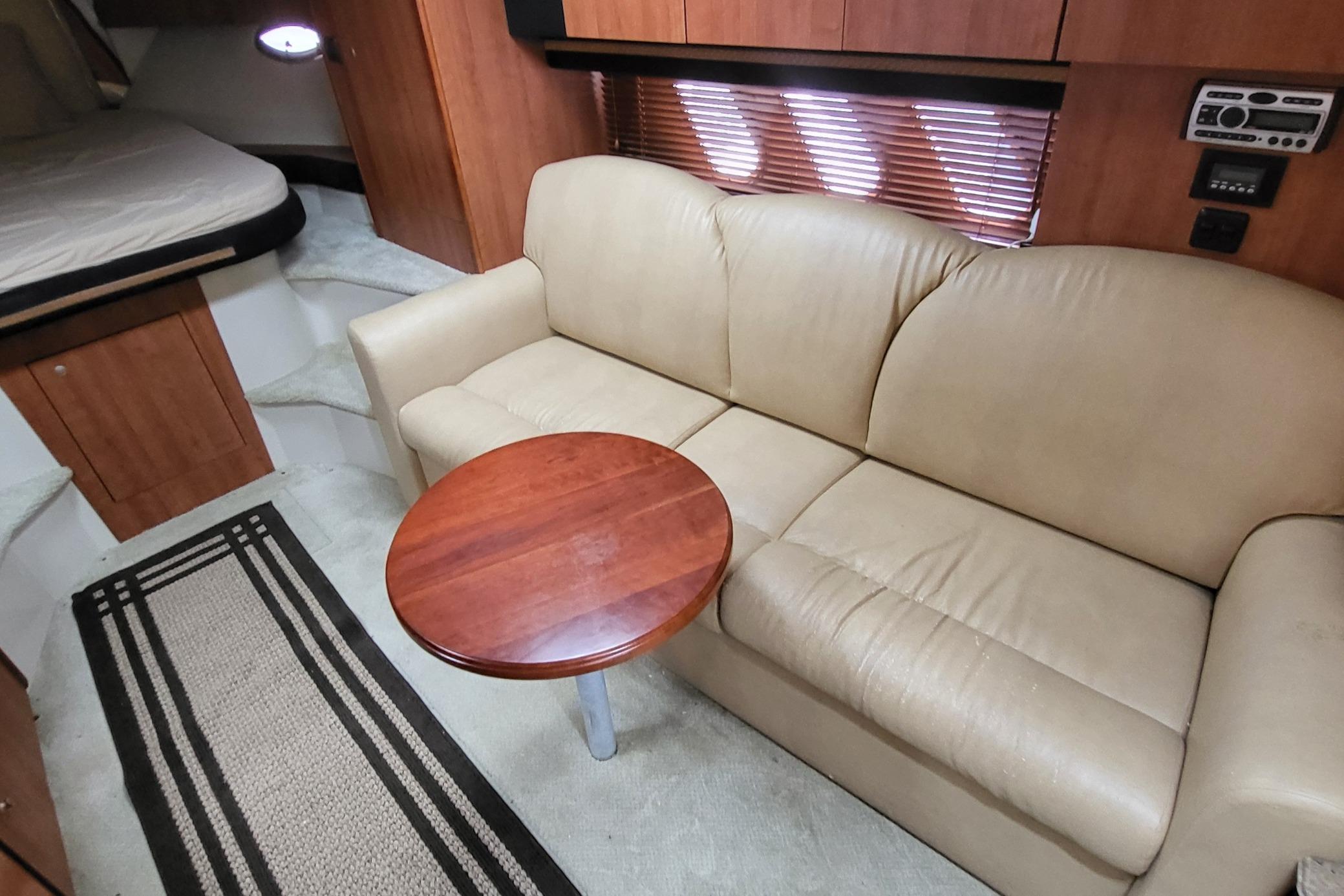 2008 Cruisers 330 yacht interior with beige sofa, wooden table, and cozy cabin space.