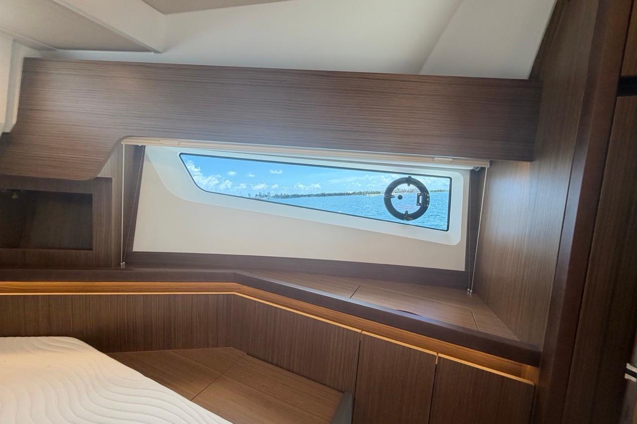 Interior cabin view of 2022 Sealine C430 yacht with wooden finish and ocean window.