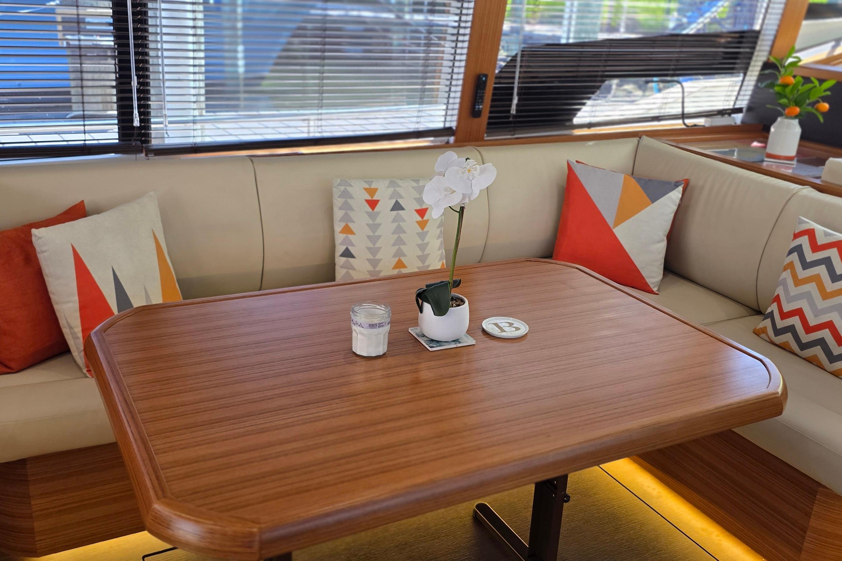 Luxurious interior of 2023 Greenline 40 yacht with modern decor and wooden table.