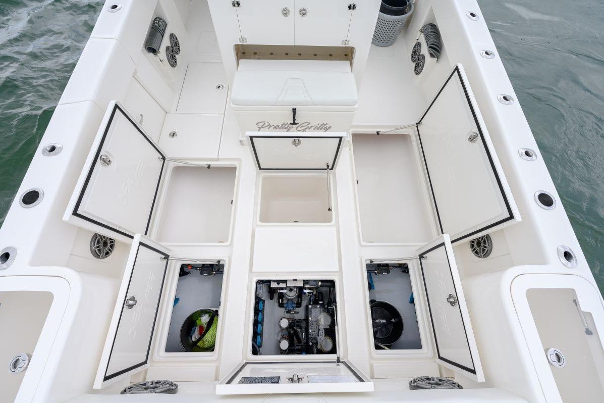 2024 SeaVee 370Z boat deck with open storage compartments and visible engine.