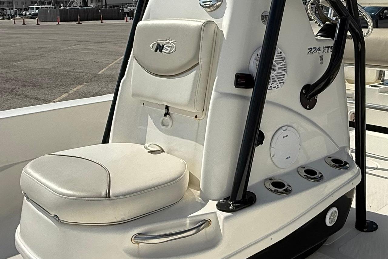 2015 NauticStar 224 XTS boat console with seating and storage compartments.