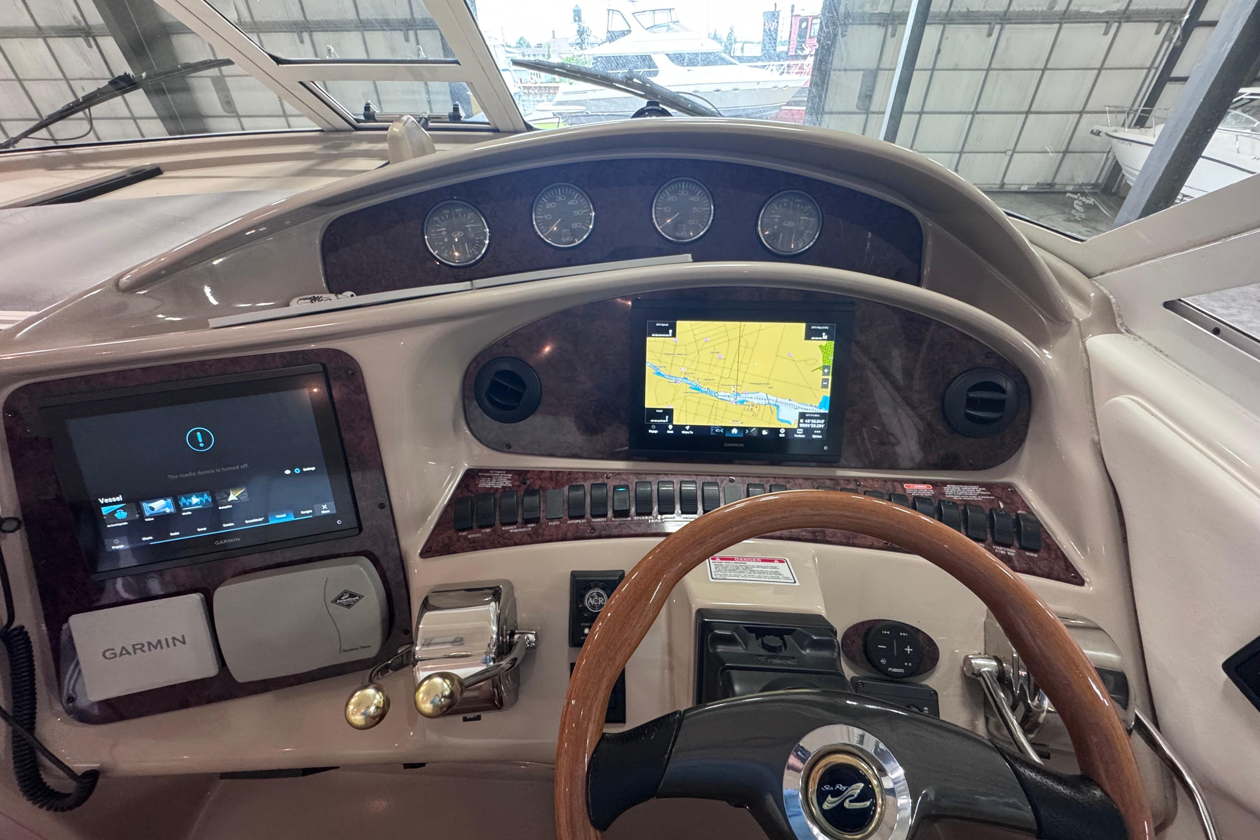 Cockpit of 2004 Sea Ray 390 Motor Yacht with Garmin navigation system and wooden steering wheel.