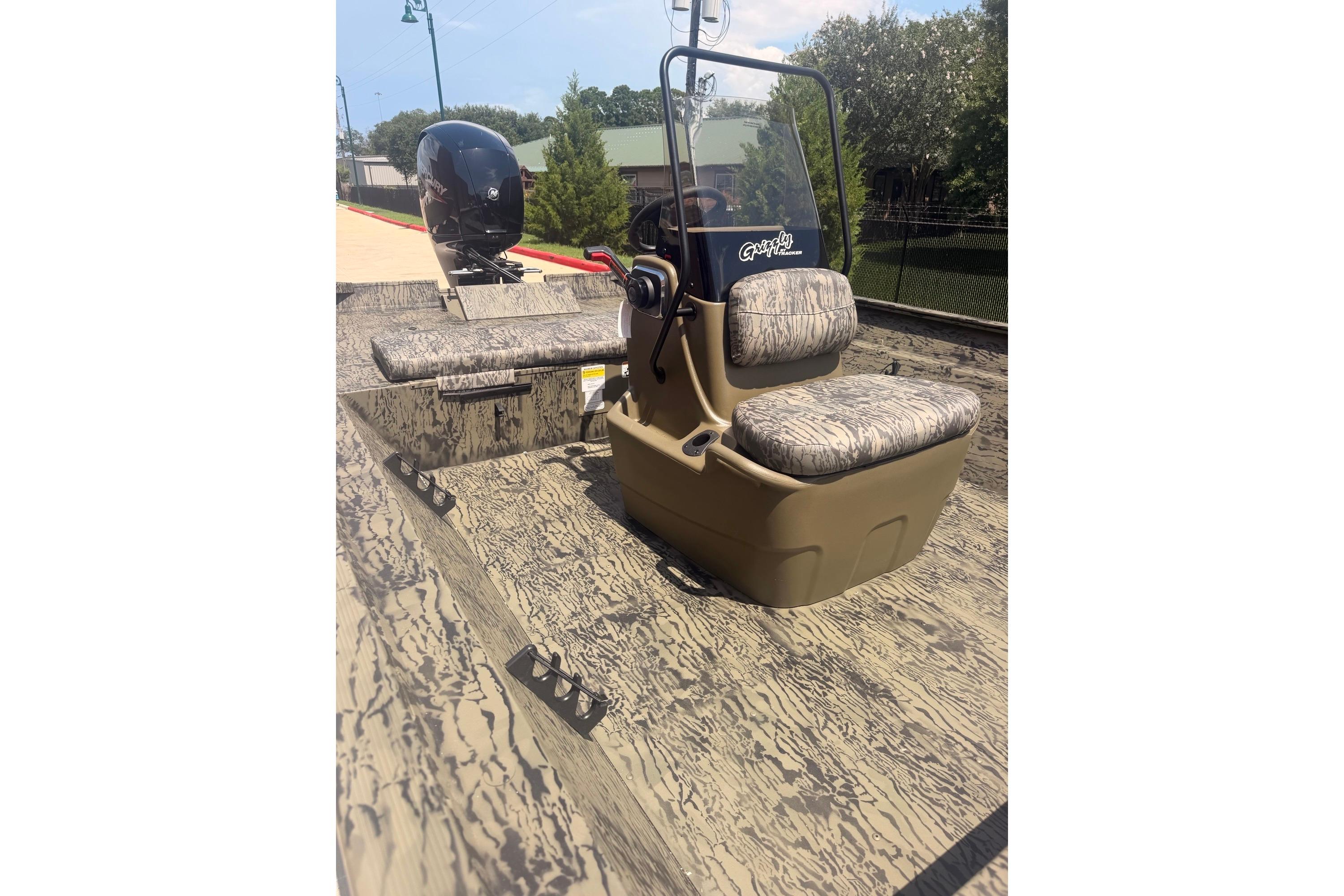 2026 Tracker Grizzly 2072 CC boat with camouflage seating and outboard motor.