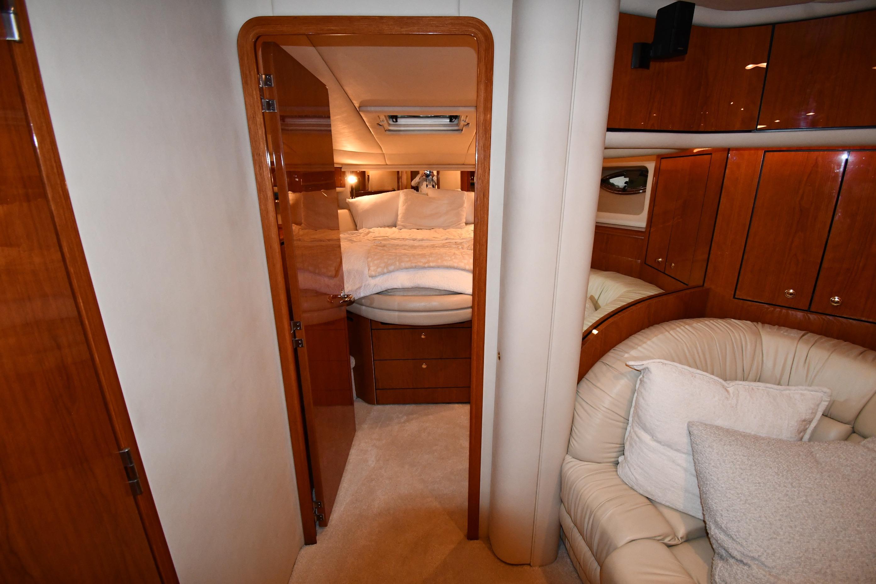 Luxurious interior of 2001 Sea Ray 540 Sundancer yacht with cozy bedroom and seating area.