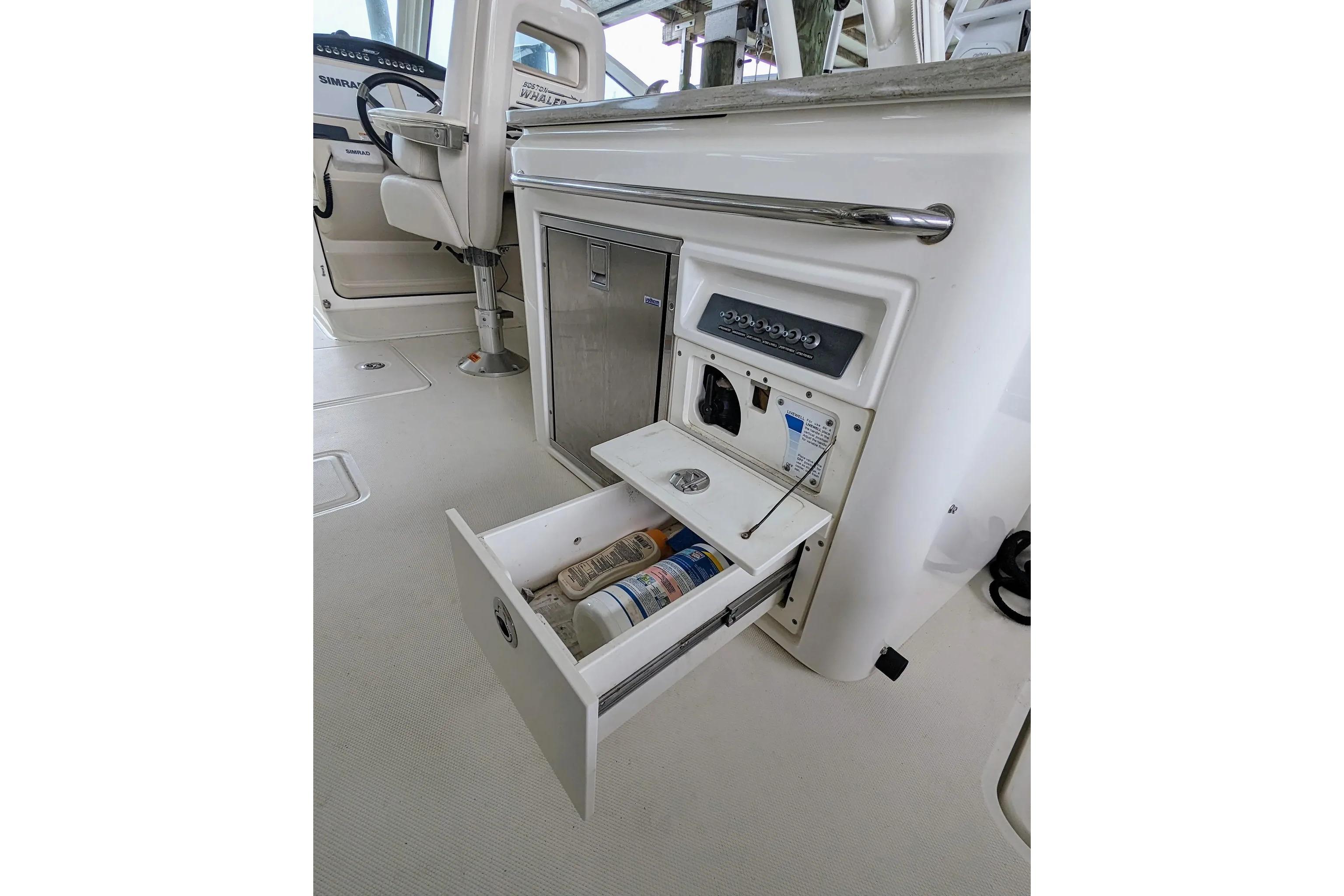 2017 Boston Whaler 320 Vantage interior with open storage compartment and helm seat.