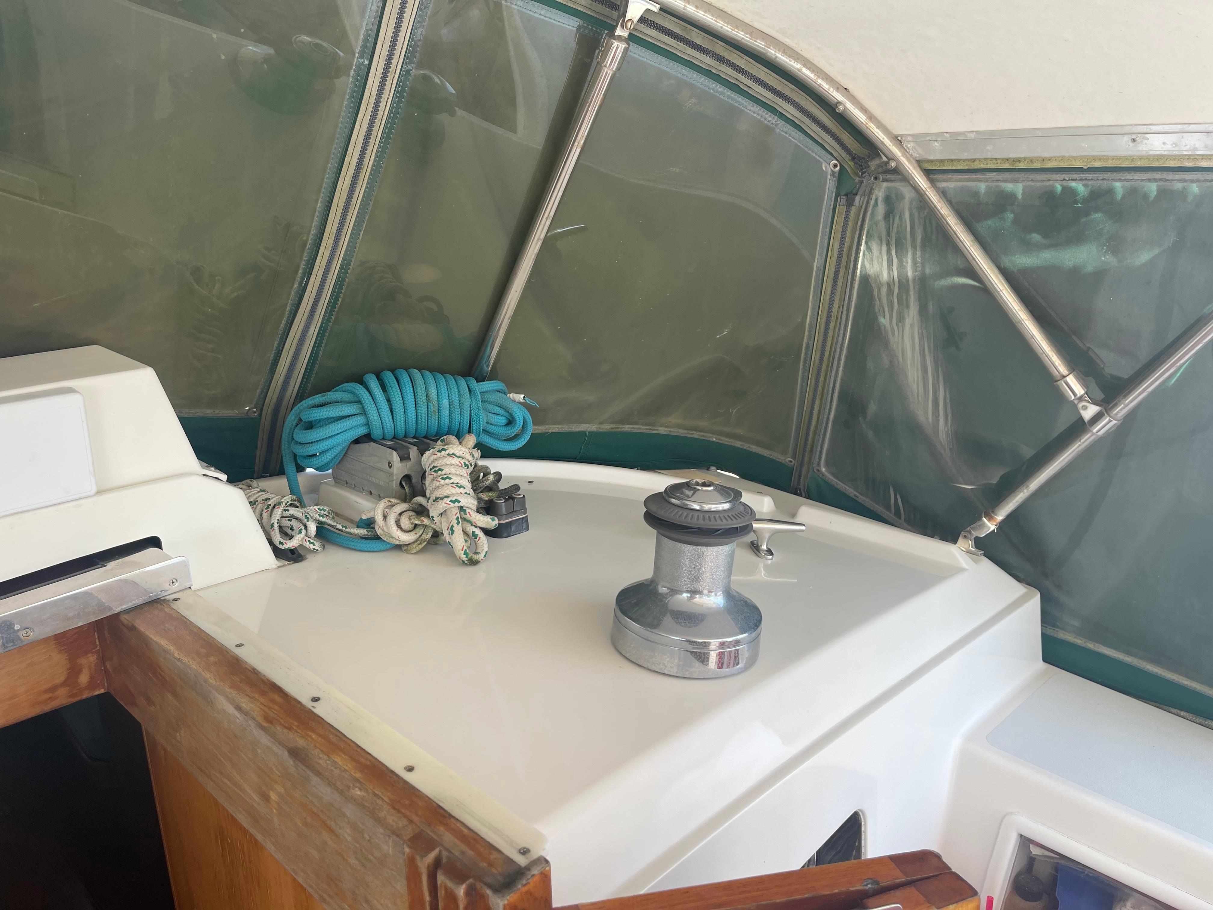Cockpit of 1995 Passport 47 AC Plan B sailboat with winch and coiled blue rope.
