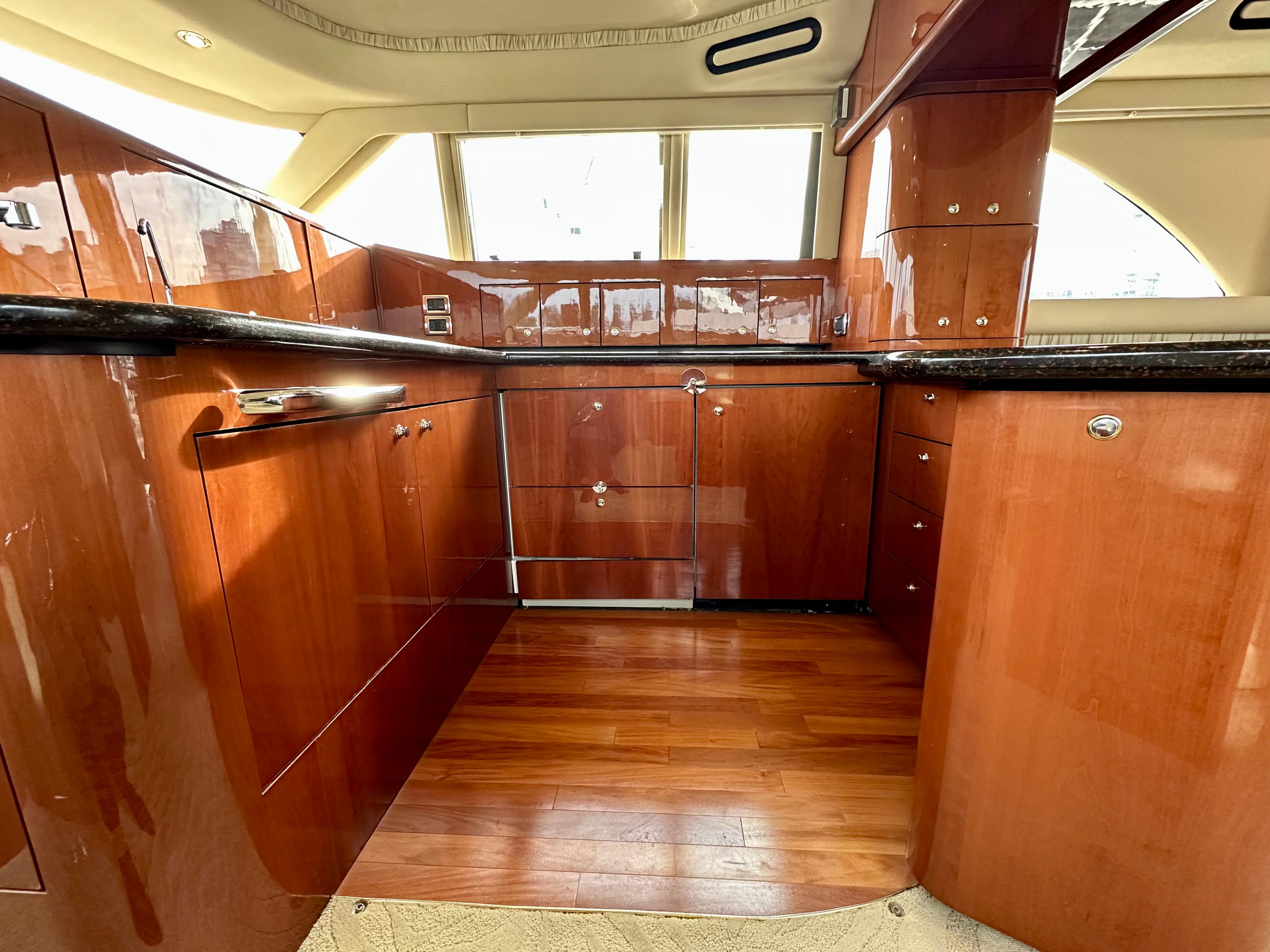 Luxurious wooden interior of a 2002 Sea Ray 560 Sedan Bridge yacht kitchen.