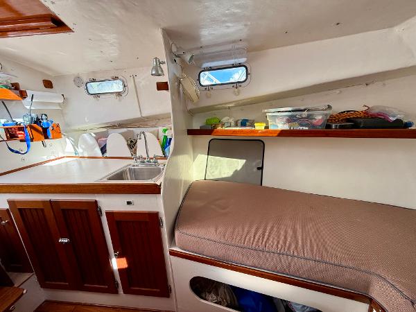 Interior of a 1978 Dyer 29 Trunk Cabin boat with kitchenette and seating area.