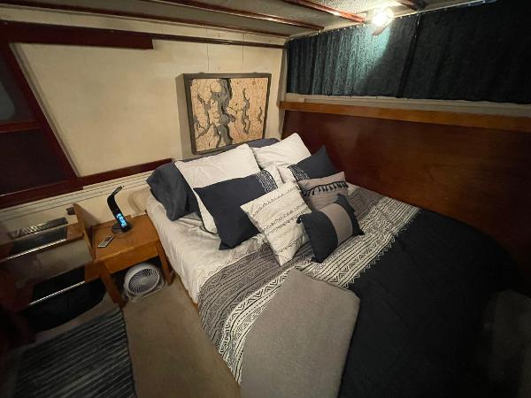 Cozy bedroom interior in a 1951 Chris-Craft Catalina boat with stylish bedding and decor.