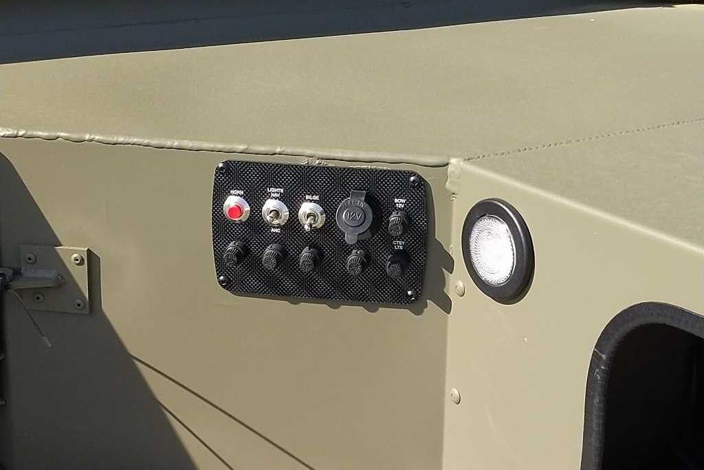 Control panel on 2026 Tracker Grizzly 1654 T Sportsman boat, featuring switches and a 12V outlet.