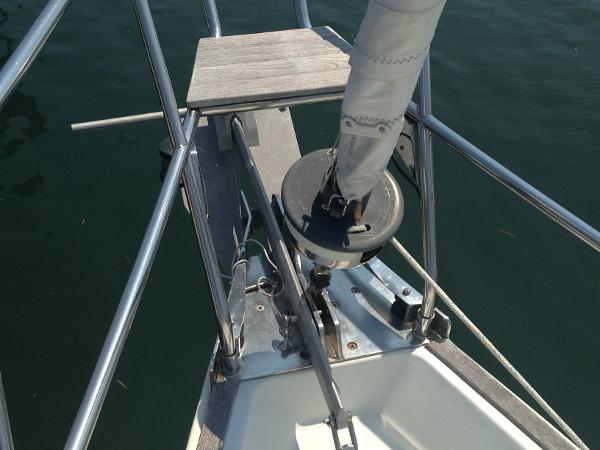 Bow of a sailboat with furling system and railing.