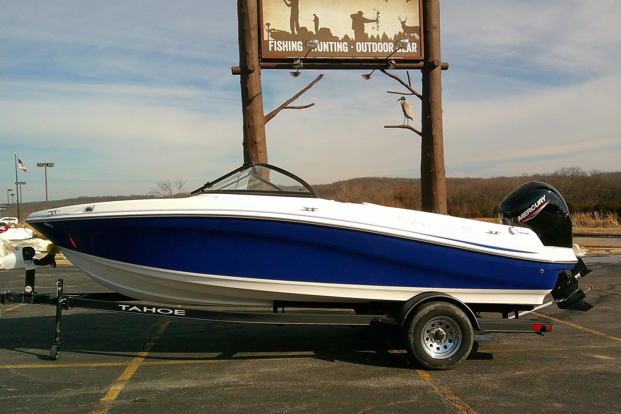 2024 Tahoe 200 S boat on trailer, parked near outdoor gear store.