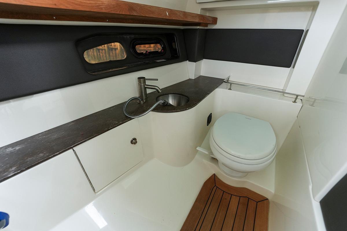 2018 Sea Ray SLX 350 boat bathroom with sink, toilet, and wooden flooring.