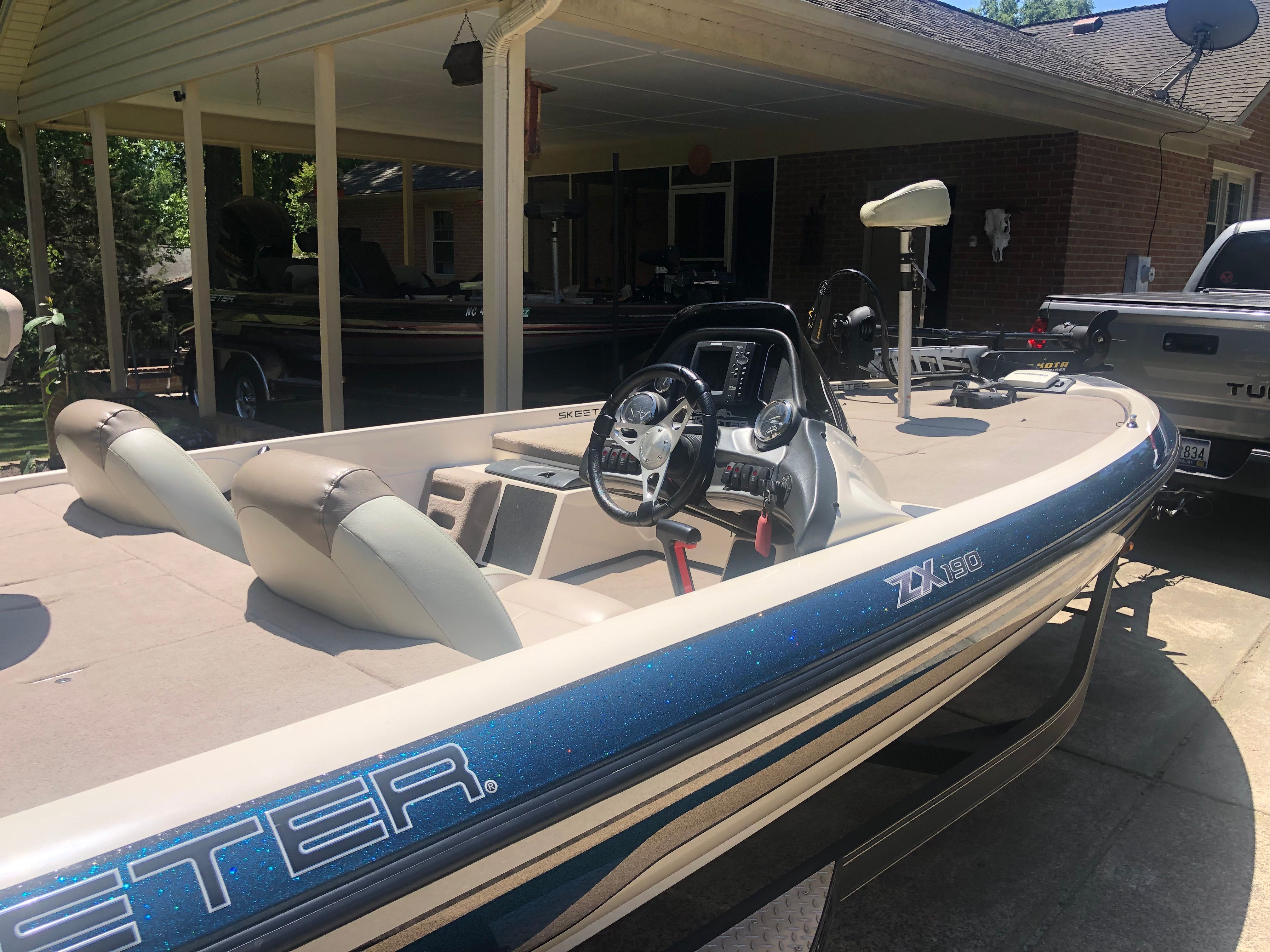 A 2012 Skeeter ZX190 boat is parked in a driveway. It features beige seats and a steering wheel.
