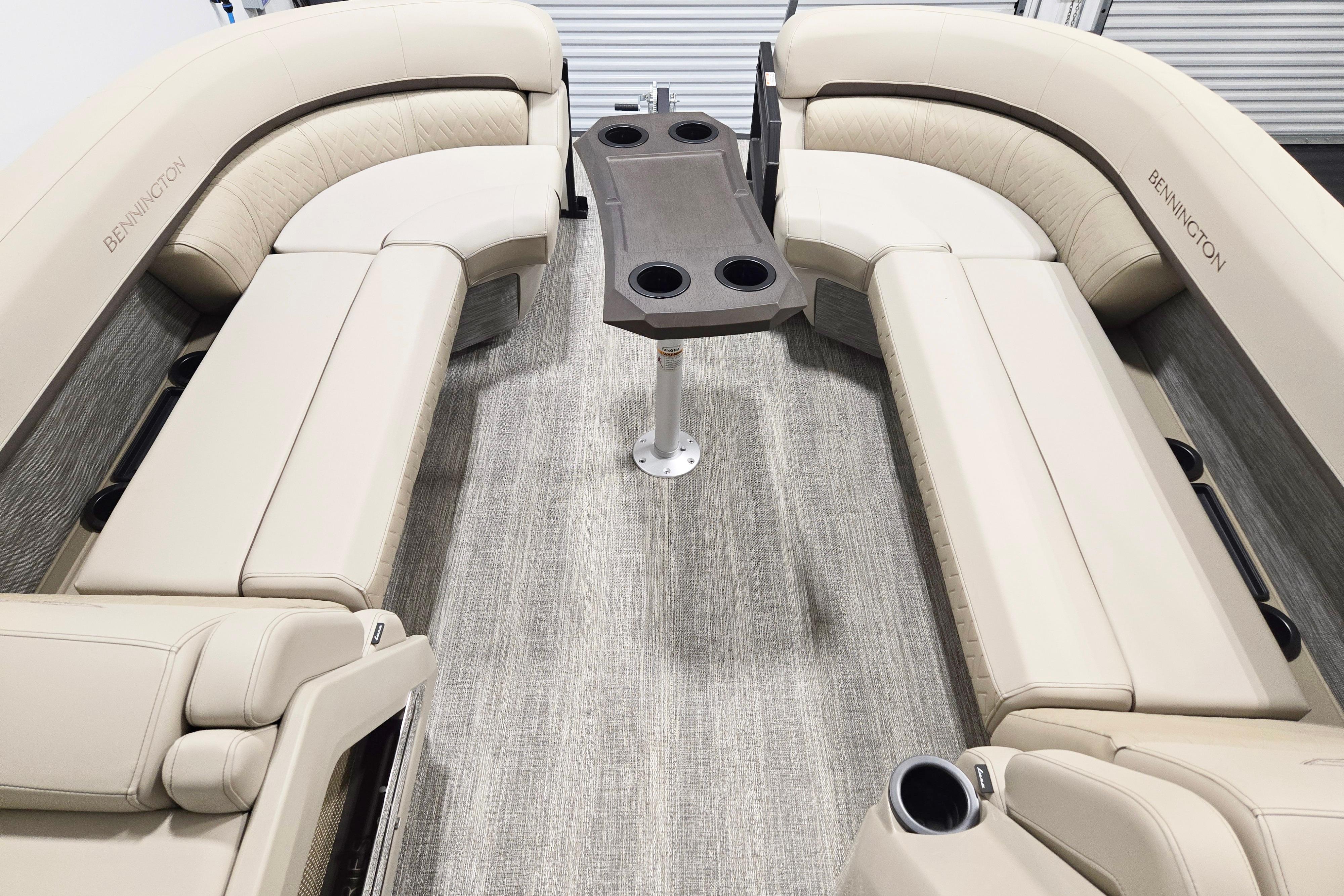 2026 Bennington 24 M boat interior with beige seating and central table.