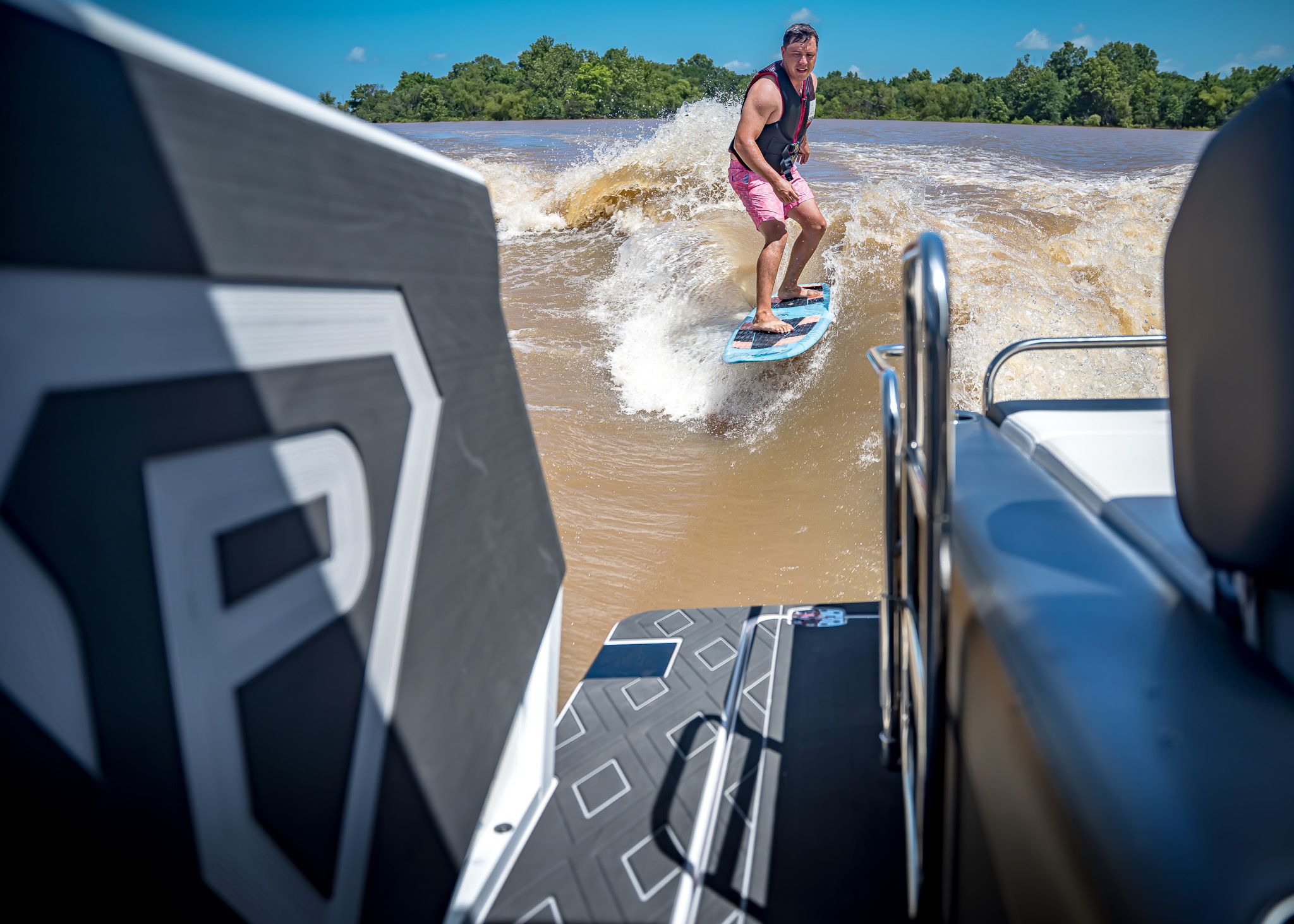 Man surfing behind Paradigm 266 SL SURF boat, 2025 model.