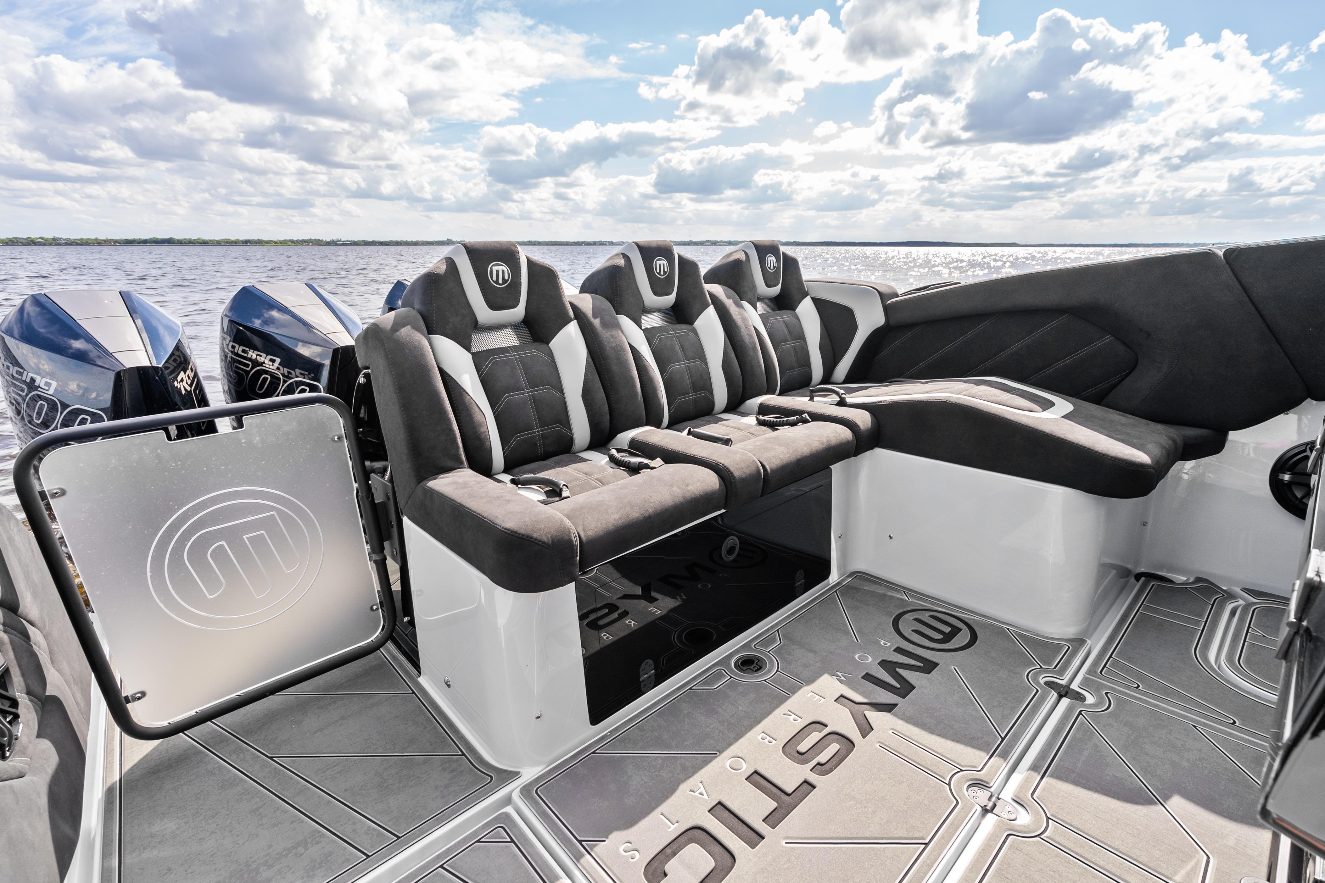 2027 Mystic Powerboats M4200 interior with luxurious seating and powerful engines on a sunny day.