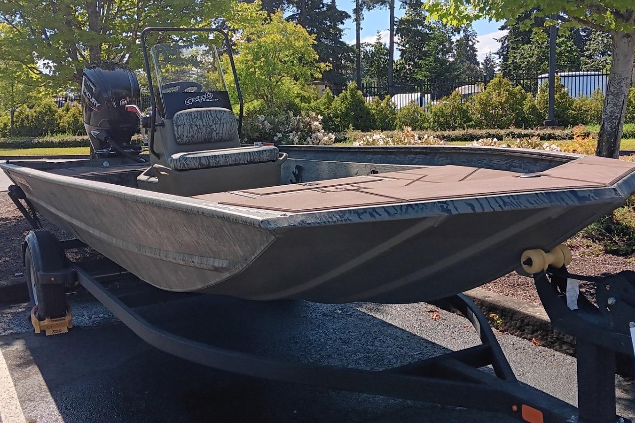 2026 Tracker Grizzly 1860 CC boat on trailer, parked outdoors.