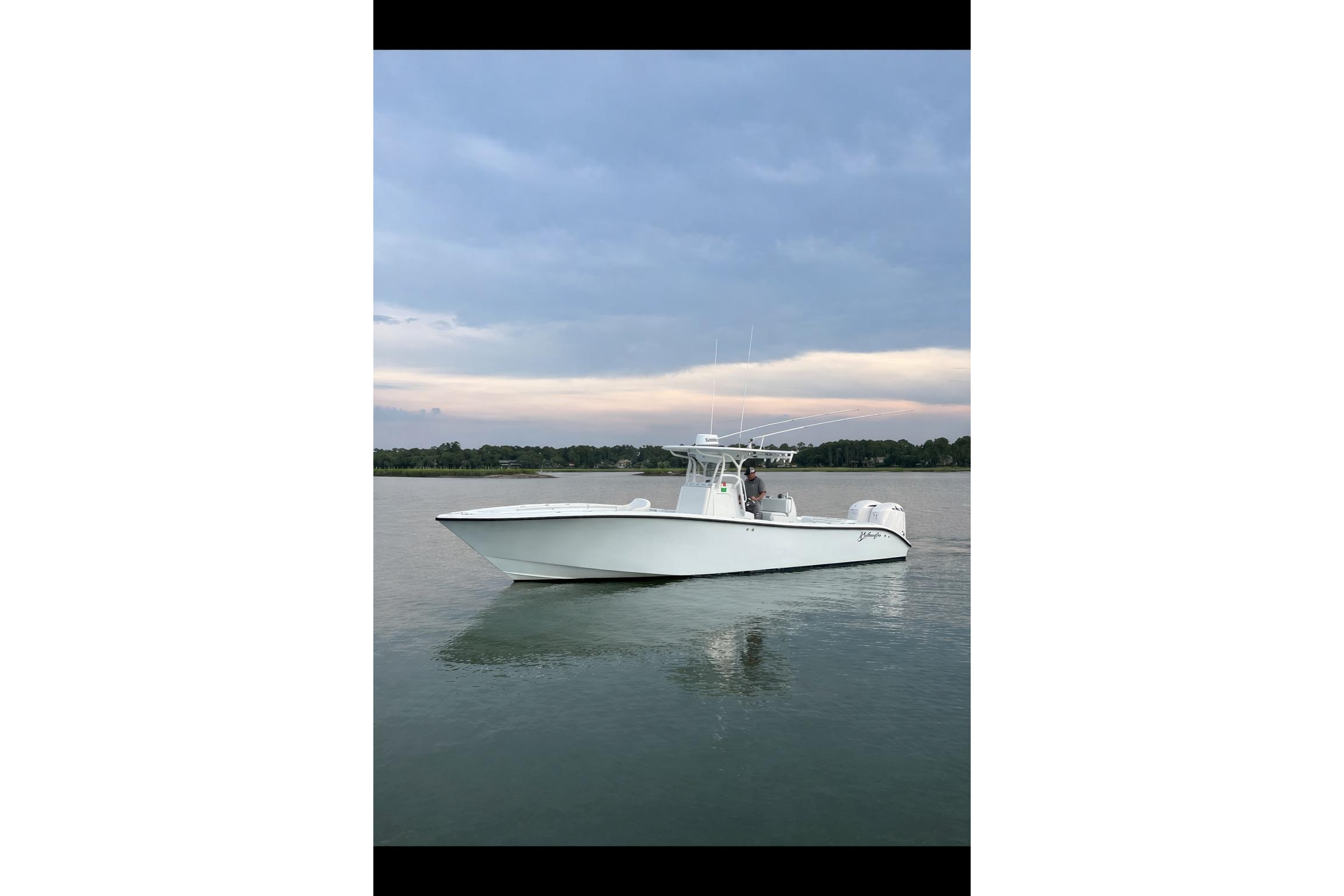 2013 Yellowfin 32 Offshore boat on calm water under a cloudy sky.