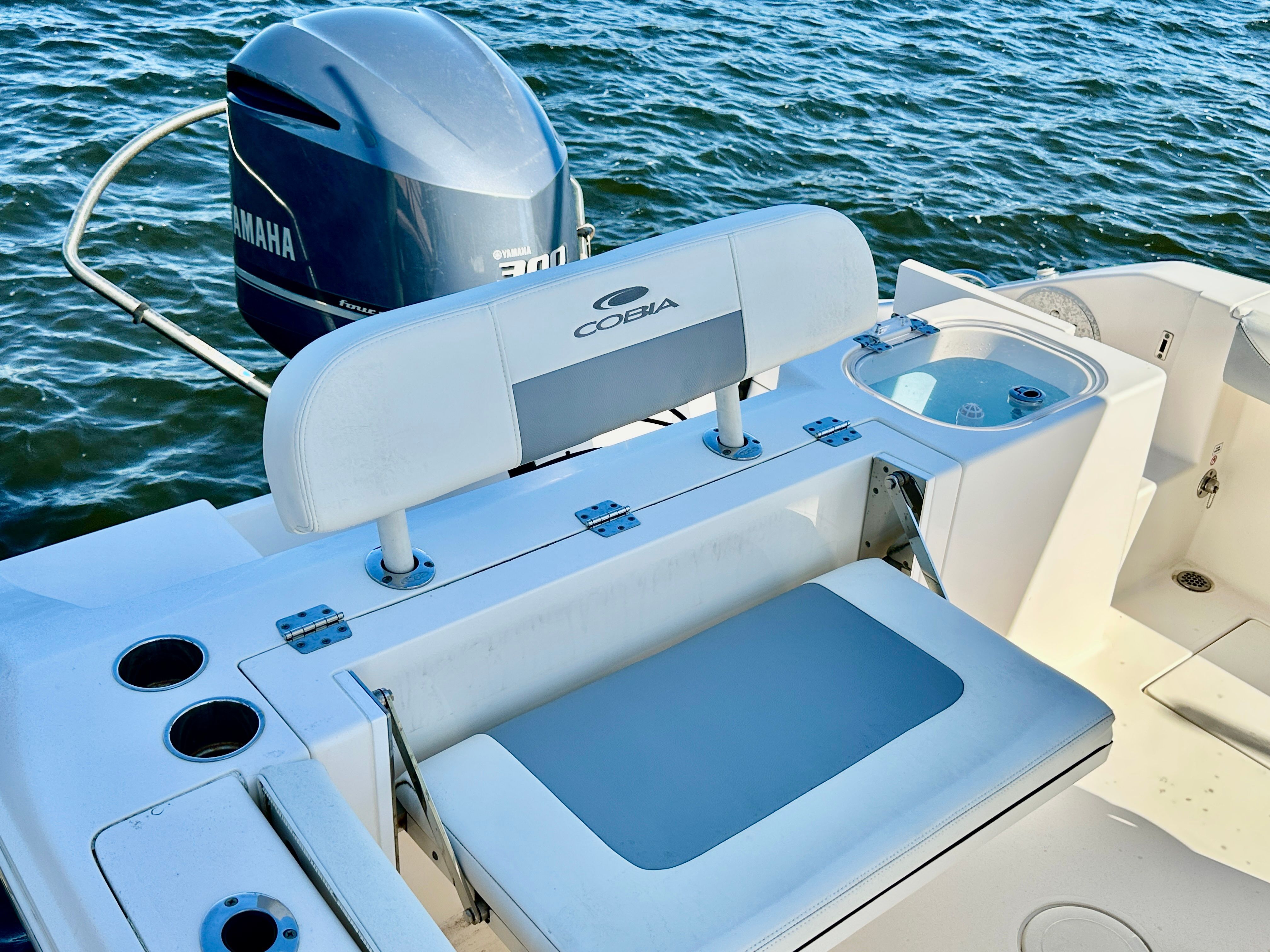 Cobia 240 Center Console from 2022 with Yamaha engine, sitting on calm water.