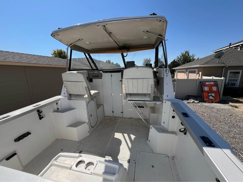 Interior of a 1999 Bayliner 2452 boat under sunny skies.