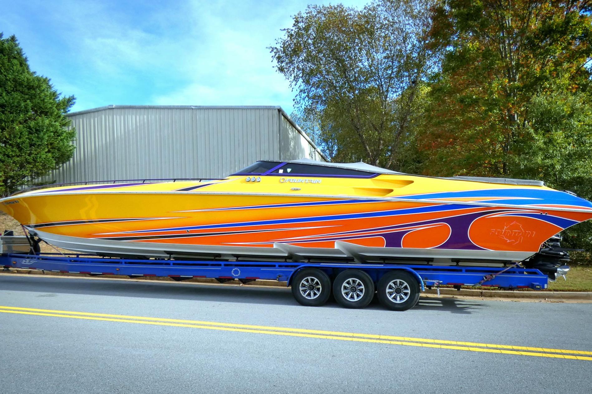 2006 Fountain 47 Lightning speedboat with vibrant yellow and blue design on a trailer.