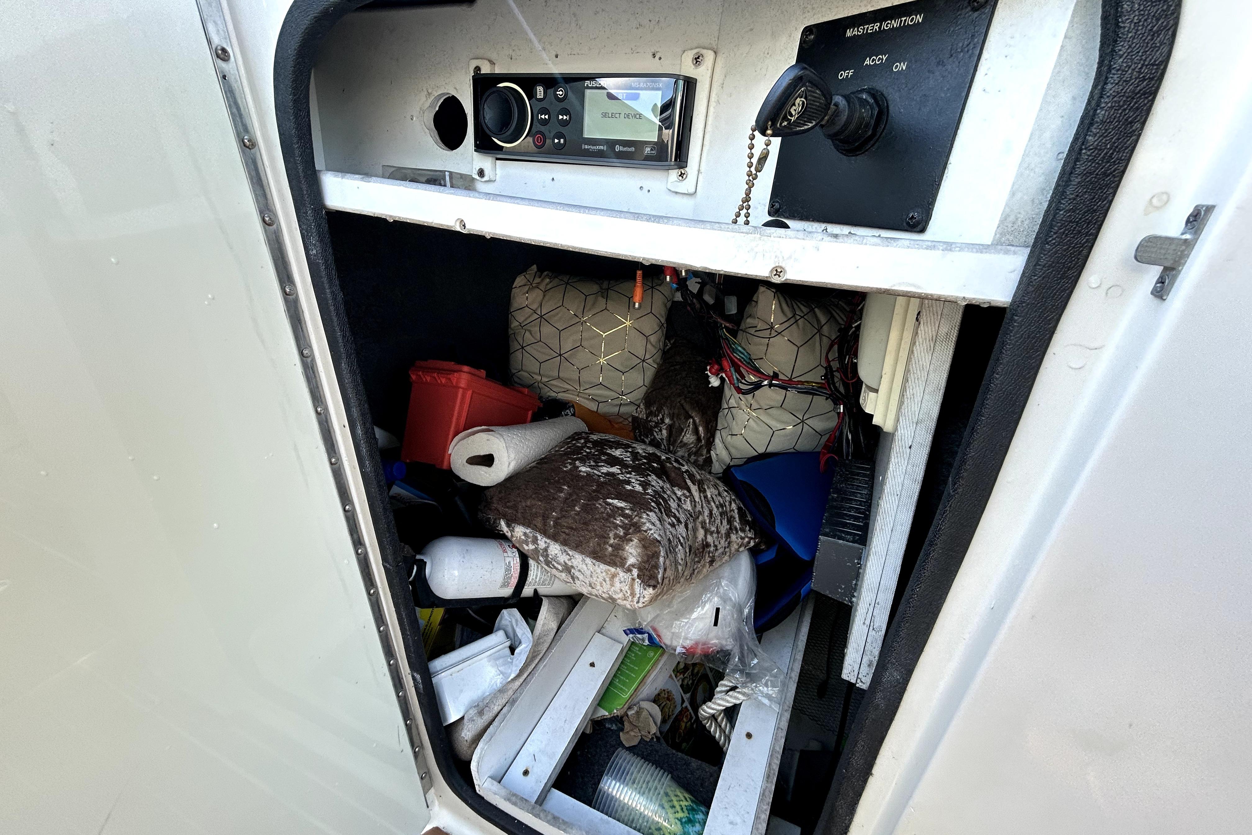 Storage compartment of a 2007 Sea Ray 260 Sundeck boat, containing various items and equipment.