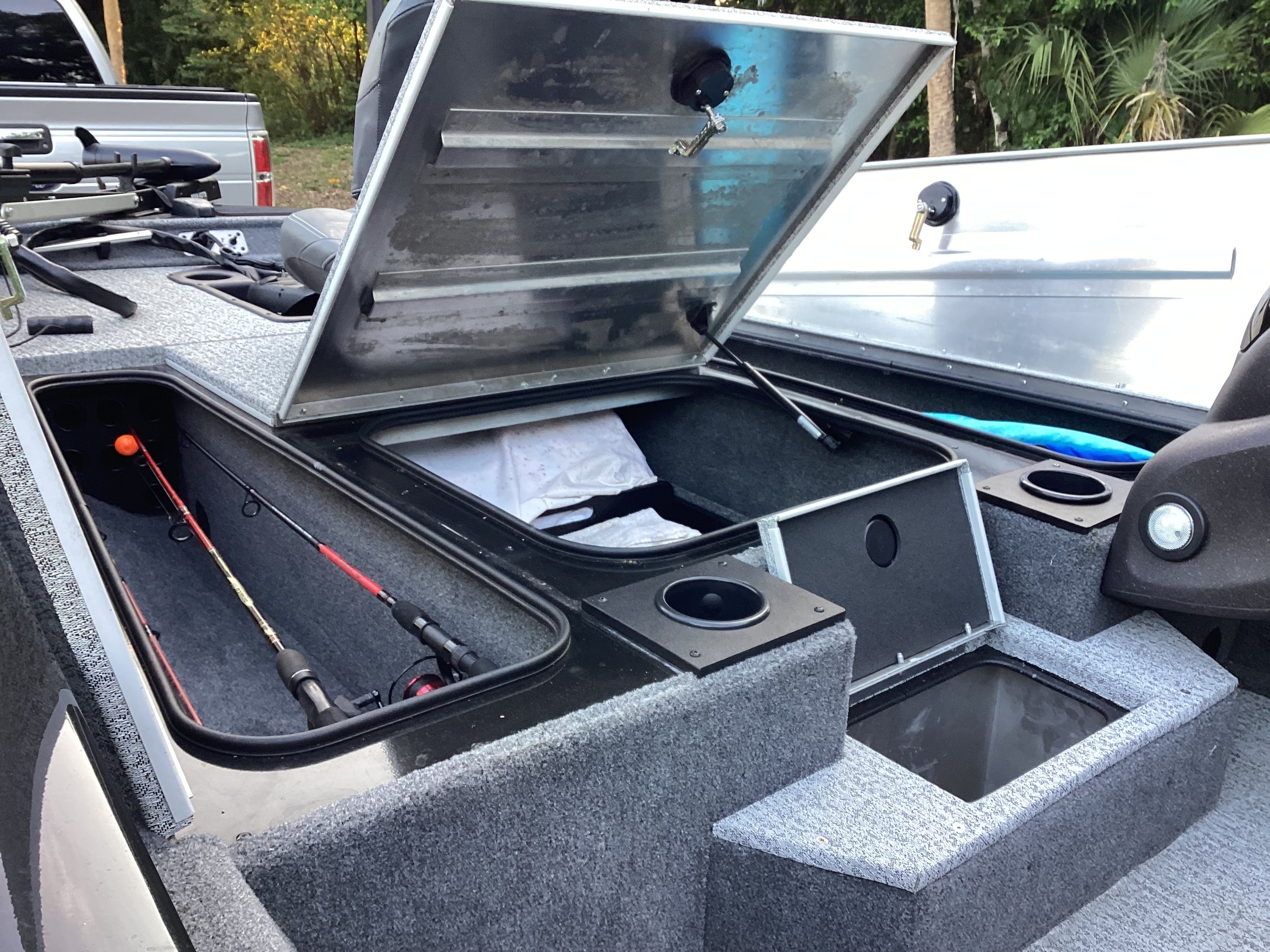 2023 Tracker PRO boat with open storage compartments and fishing rods.
